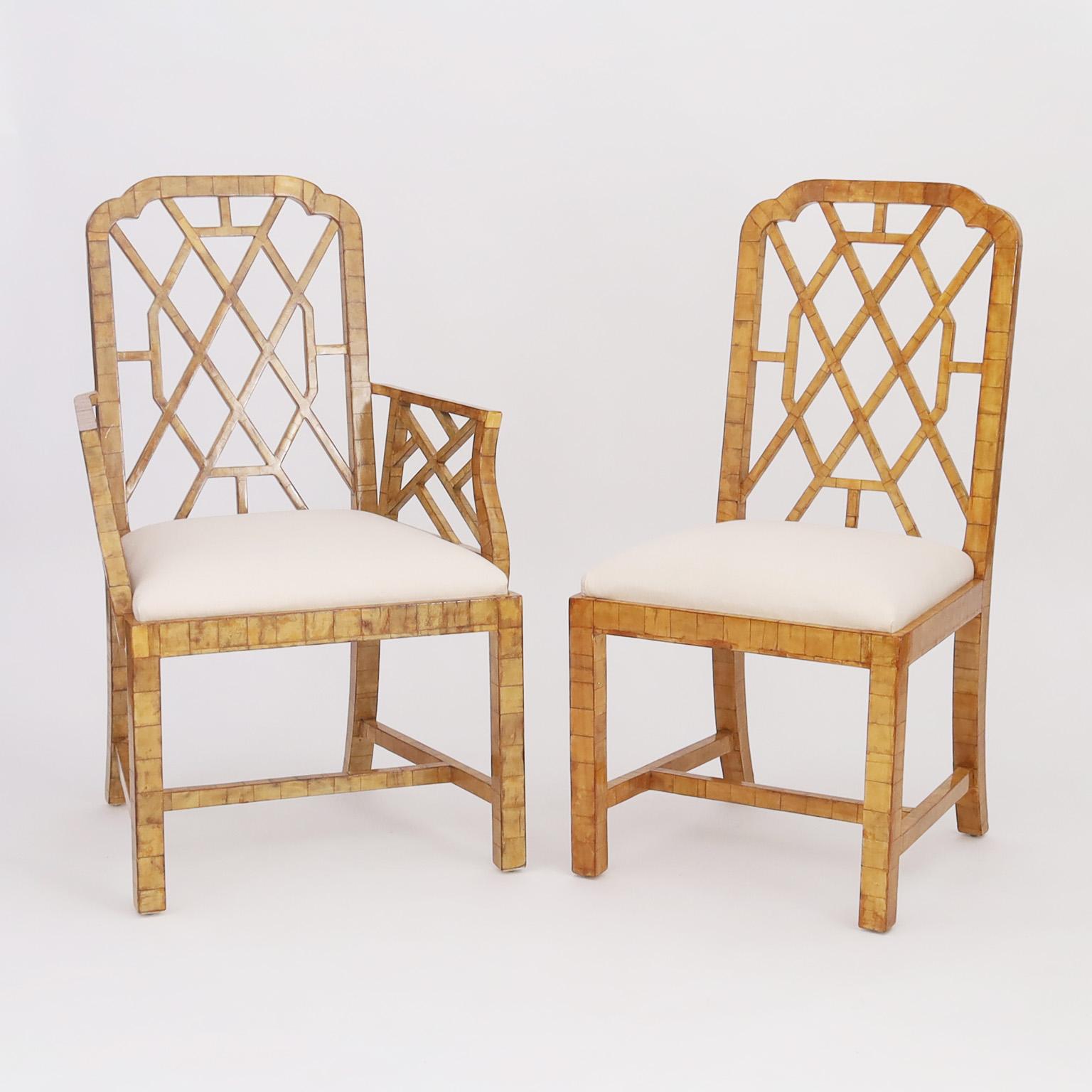 Impressive set of four Chinese Chippendale style dining chairs, two arm and two side entirely clad in a bone veneer mosaic.

Armchairs H: 39 W: 22.5 D: 18 
Side chairs H: 39 W: 19.5 D: 21 
Seat Height: 18.