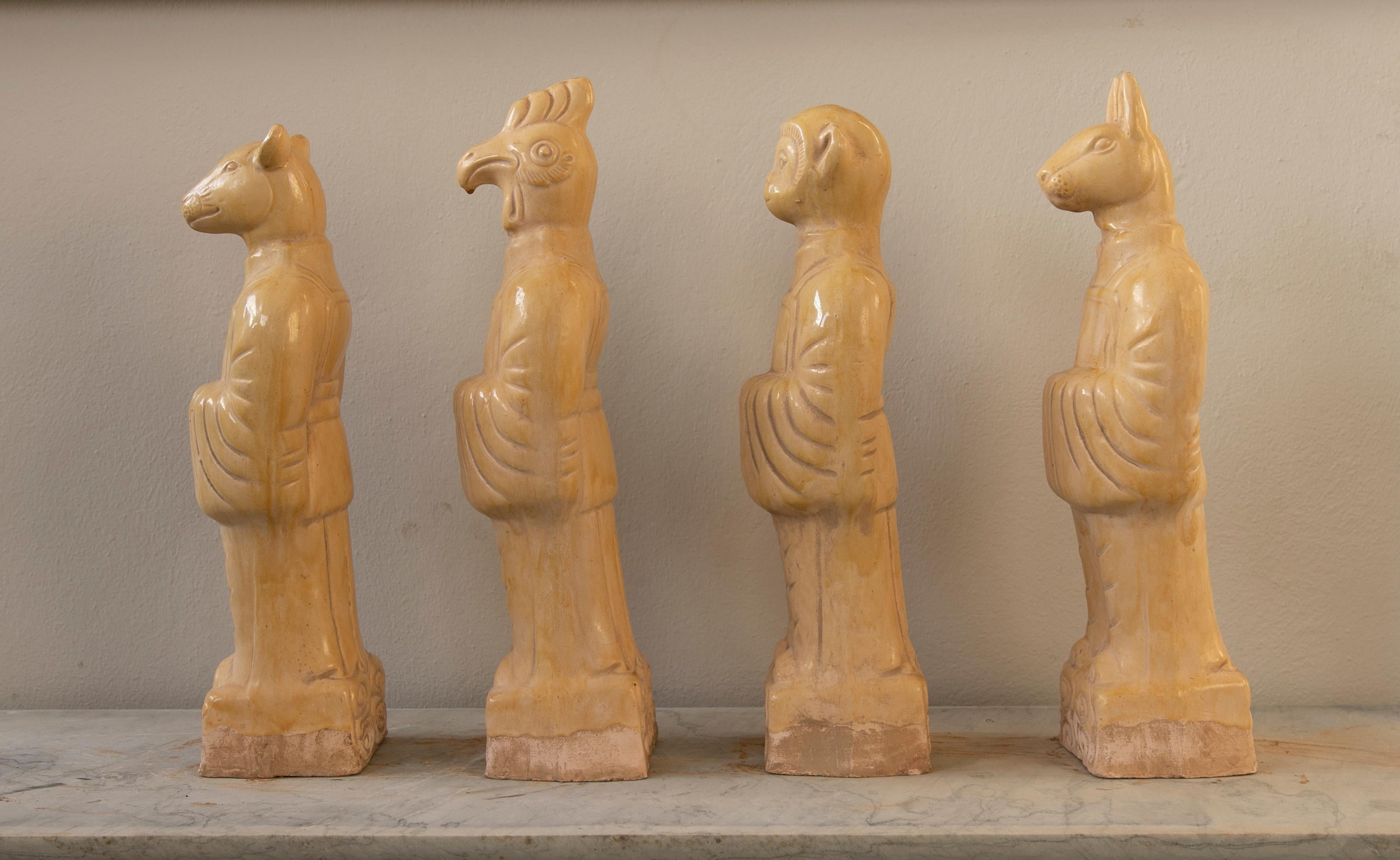 Set of four Chinese mythological gods in beige glazed terracotta.