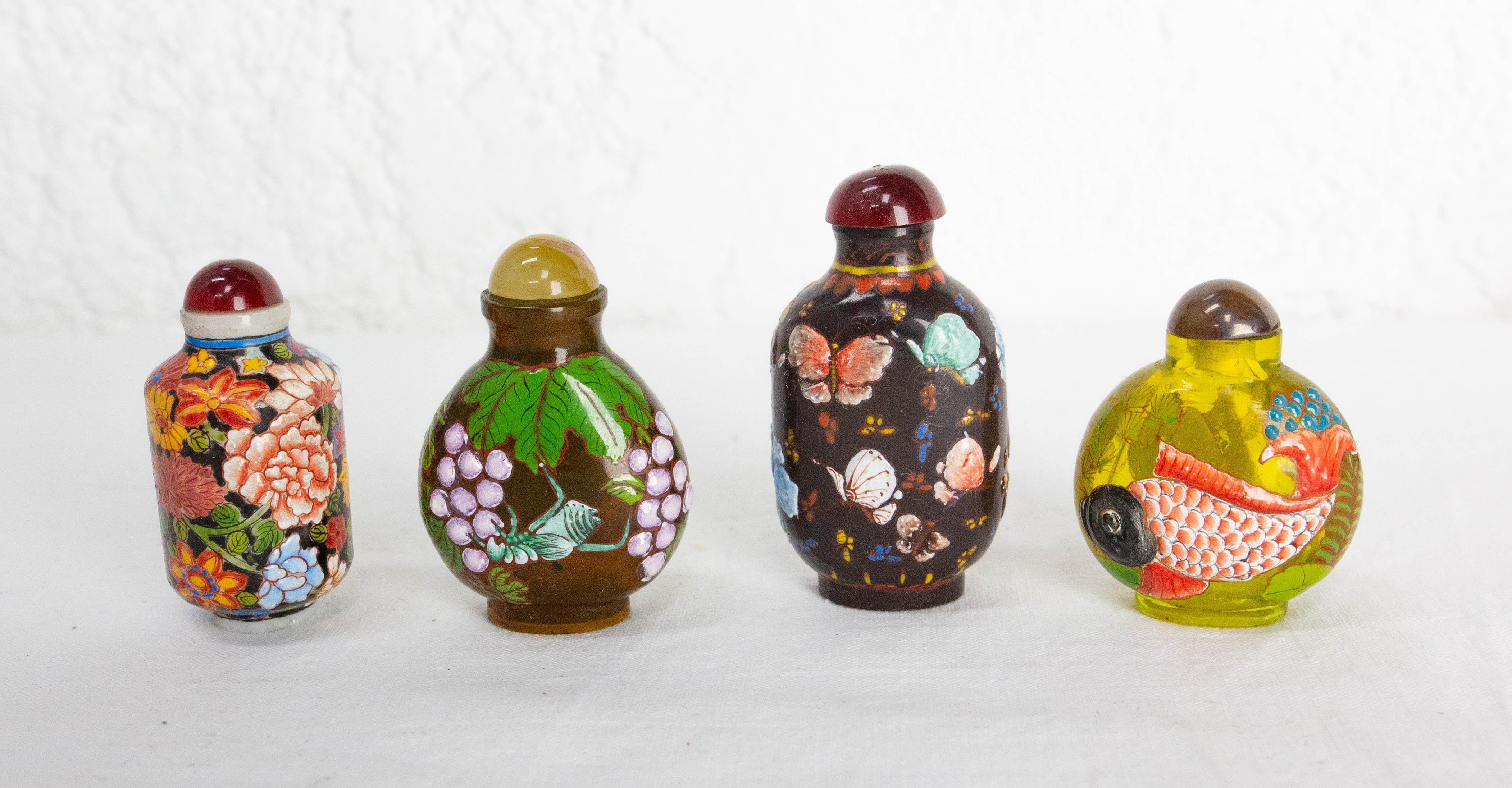 Ensemble de quatre flacons à priser fabriqués au début du 20e siècle
Porcelaine, verre coloré et onyx (un bouchon est en onyx, voir photos).
diverses dimensions : entre 2,76 in. et 1,97 in. de haut (5 à 7 cm).
Décoration inspirée de la nature :
