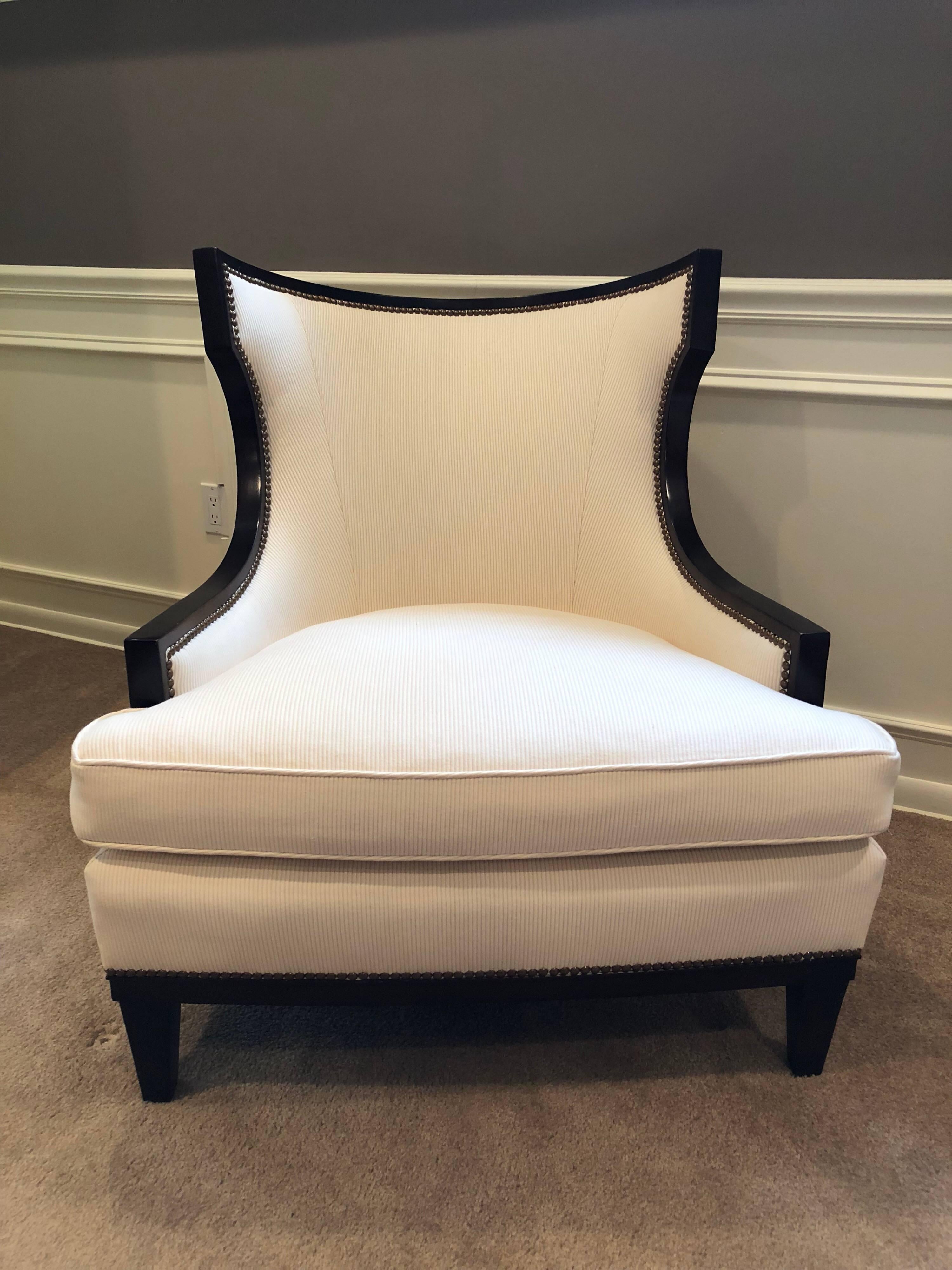 A set of four Barbara Barry curved back armchairs in mahogany with off-white ribbed upholstery.