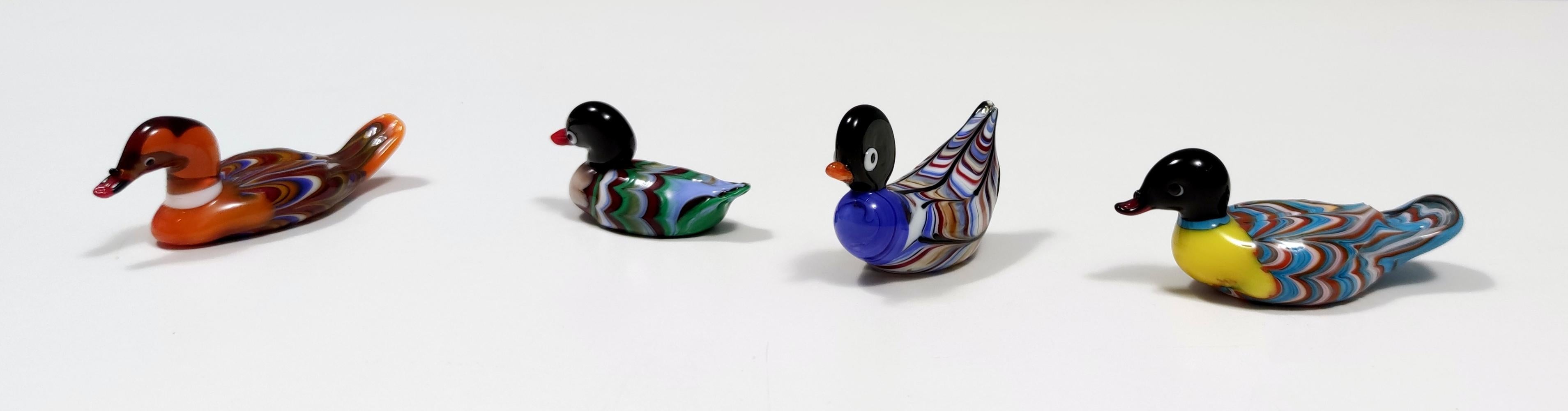 These ducks are made in murano glass.
They are vintage, therefore they might show slight traces of use, but they can be considered as in perfect original condition.

Measures:
Green - 6 x 2.5 H 3 cm 
Orange - 9 x 3 H 3 cm 
Yellow - 9 x 3 H 3