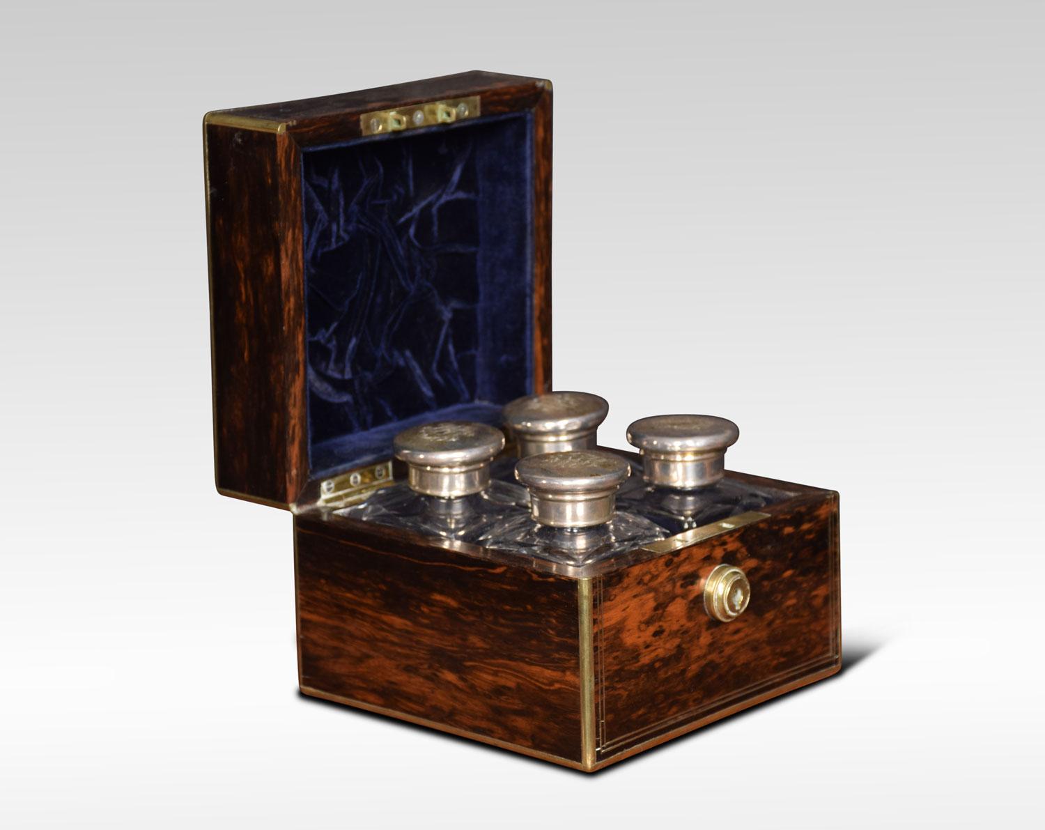 A set of four cologne or perfume bottles in fitted Coromandel and brass case. The four silvered lids with etched motifs above cut-glass square bottles. The box marked Austin of Dublin. Retaining its original leather outer case.
Dimensions:
Height