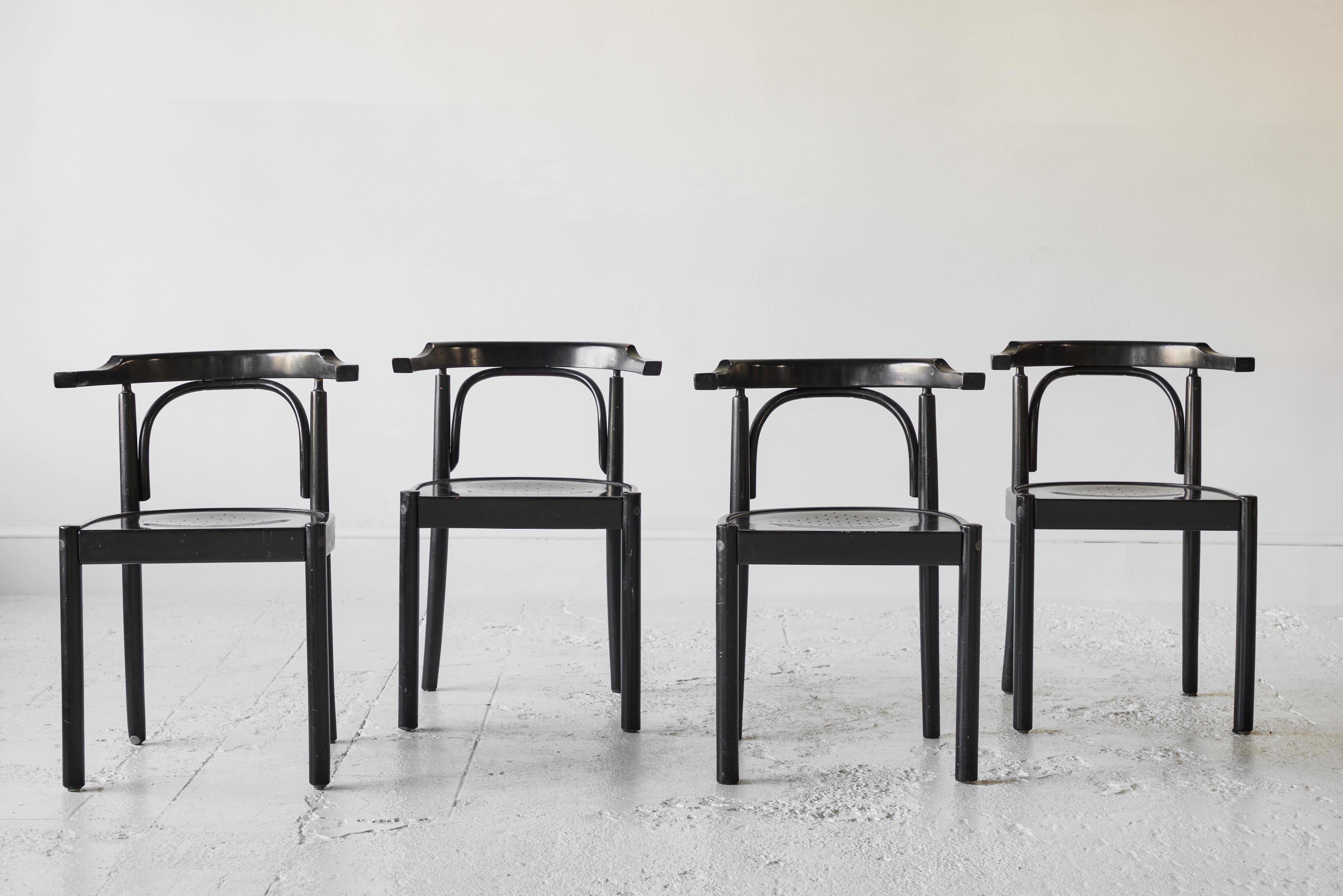 Beautiful set of four black painted, curved back chairs. With distinct bentwood details, perforated seats, and a simplistic yet chic form, these are the perfect addition to a breakfast room. These are cleaned and waxed and ready for use.
