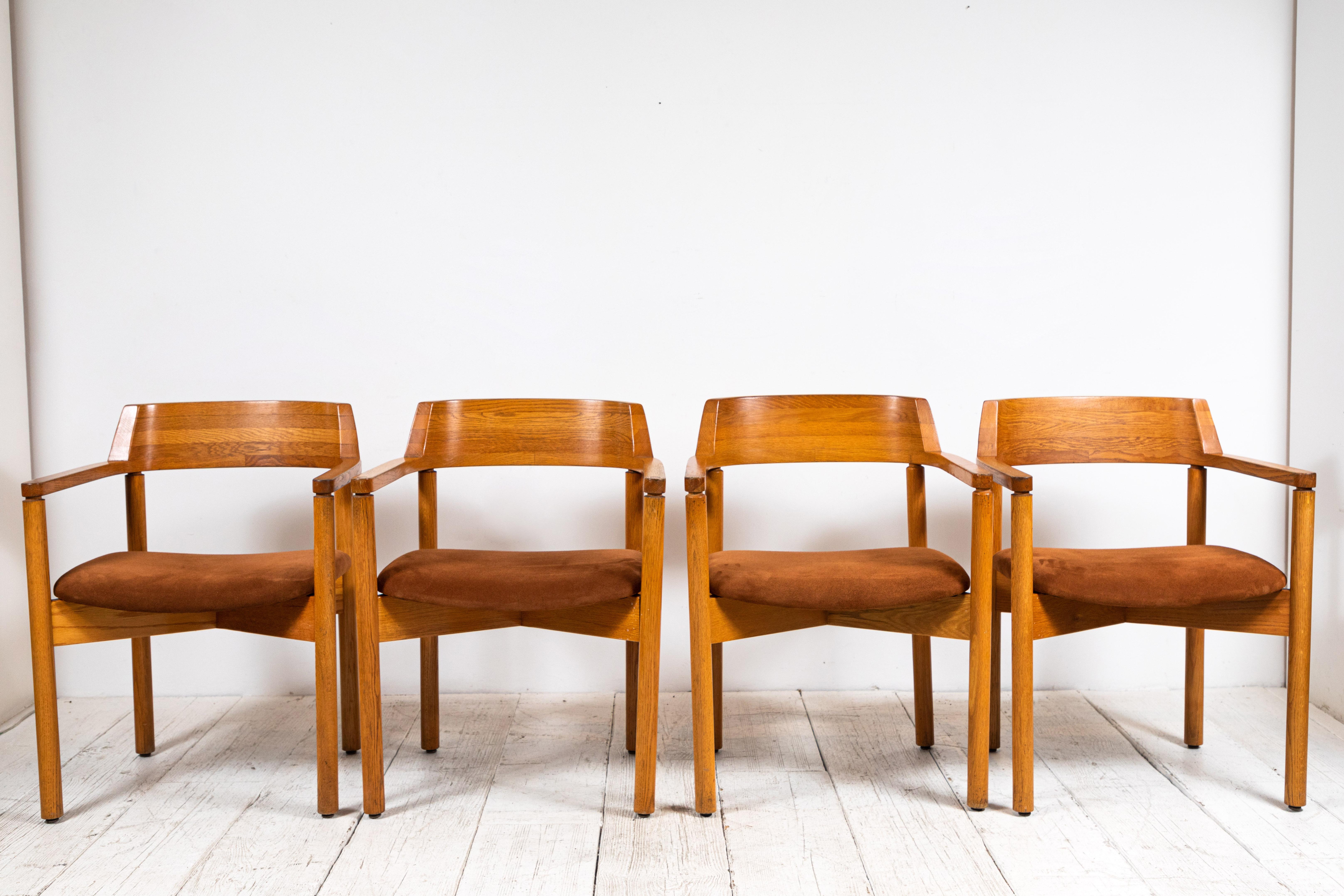 Set of four midcentury dining arm chairs with curved back newly upholstered in brown suede.