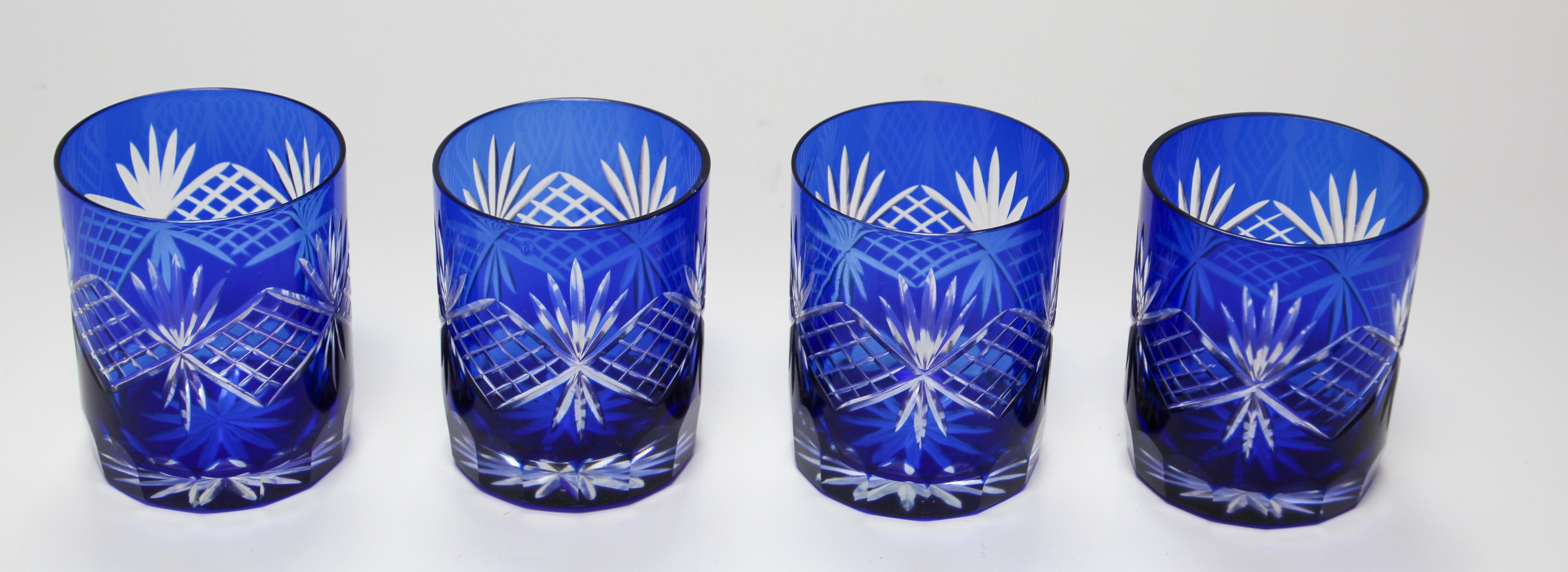 Set of four whiskey glasses tumbler cobalt blue crystal. 
The vibrant hand blown rich sapphire blue jewel sapphire blue crystal glass is cut to clear to reveal a lovely pattern with clean lines. 
Set of four rock whiskey or water barware, drinking