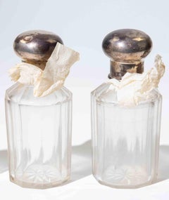 Set di quattro bottiglie da toilette in vetro tagliato con tappi in argento, anni '70