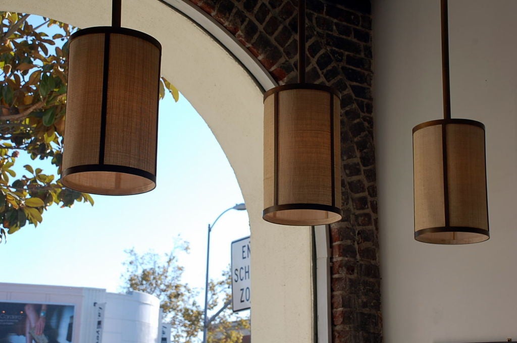 French Set of Four 'Cylindre' Patinated Brass and Raffia Pendant Lights, Design Frères For Sale