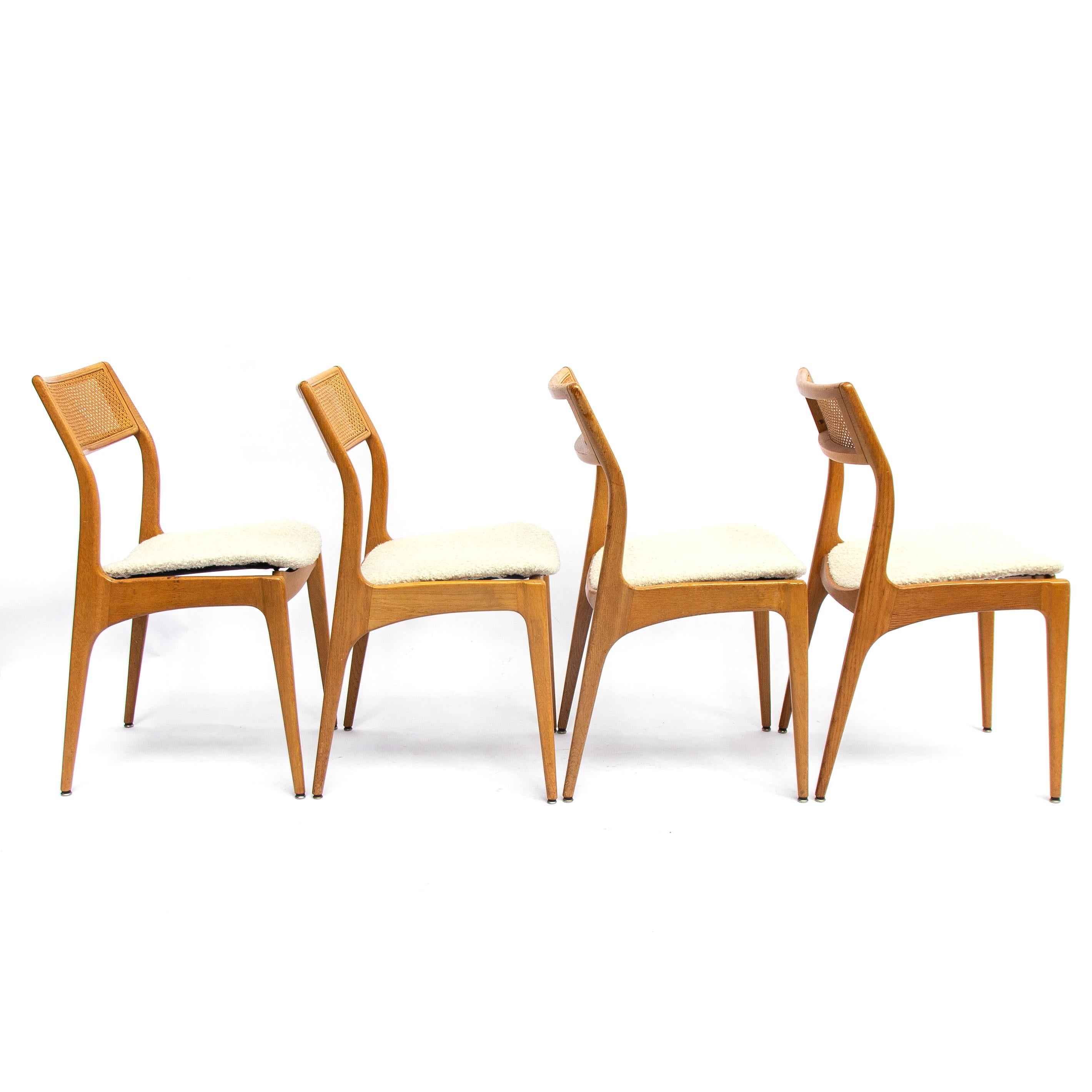 Set of four Danish midcentury oak dining chairs with a webbing back newly upholstered. The typical soft feminine shaped edges refer to the populair Danish hand of design. These chairs are special with the diagonal webbing back. Production date app