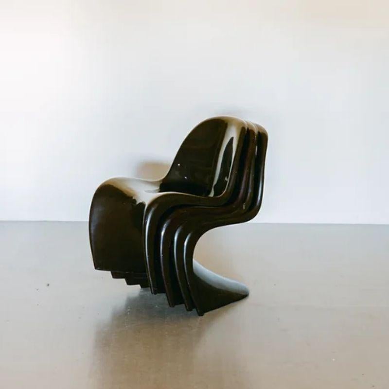 A set of four Danish brown polypropylene cantilevered chairs designed by Verner Panton (1926-1998), from the 1990s inspired by a 1970s design.

This iconic Panton chair is durable, easy to clean and stackable. The chairs are in worn condition with