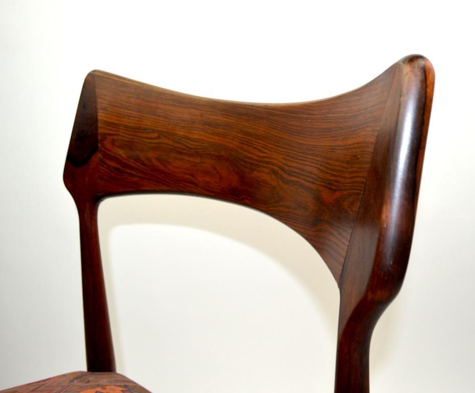 Slick and sophisticated set of rosewood dining chairs, made in Denmark, attributed to AM Mobler. Clean, original condition, ready to use. Measures: Seat Height 17 inches.

 