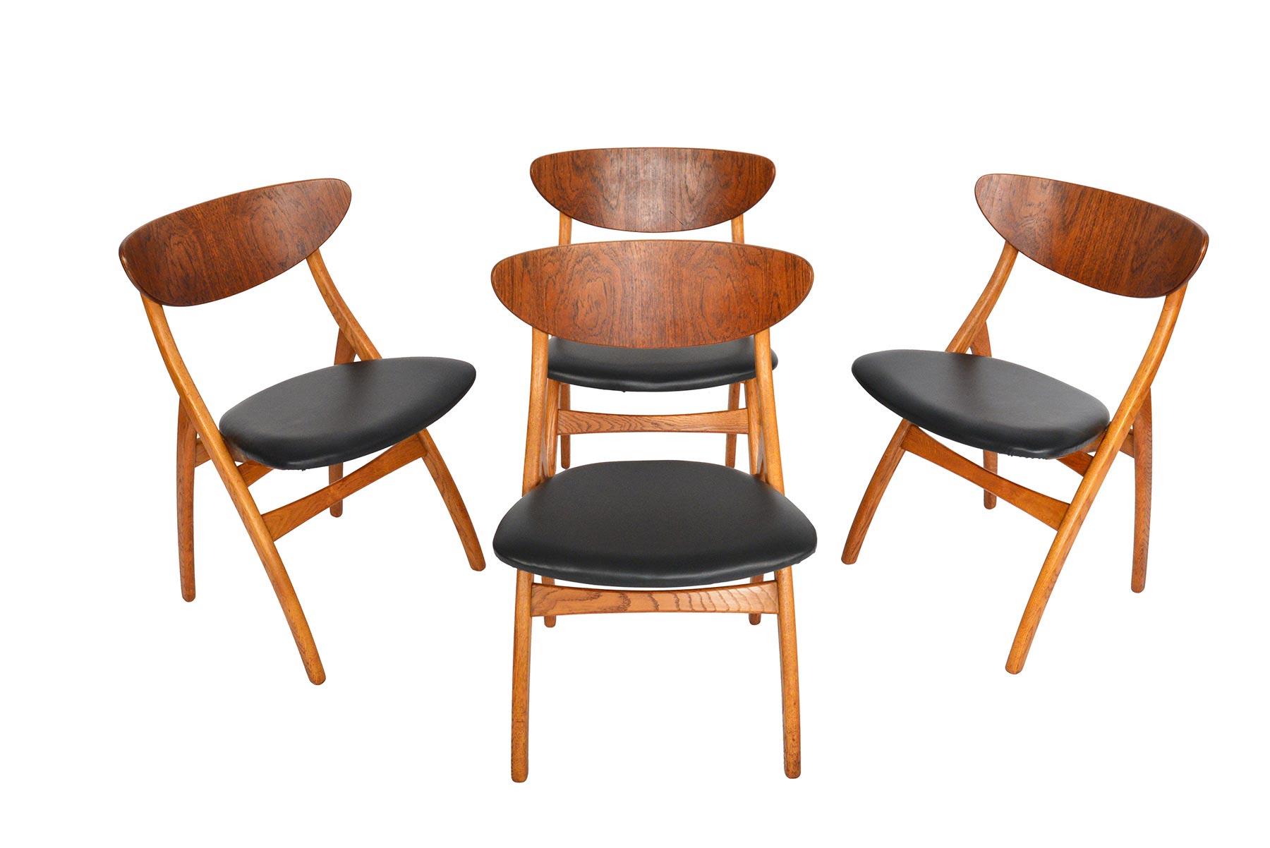 This set of four Danish modern dining chairs is a perfect example of organic design achieved through ingenious construction. Bent teak backrests curve to provide support. A solid quarter- sawn oak leg swags forward with rear legs canted back. A