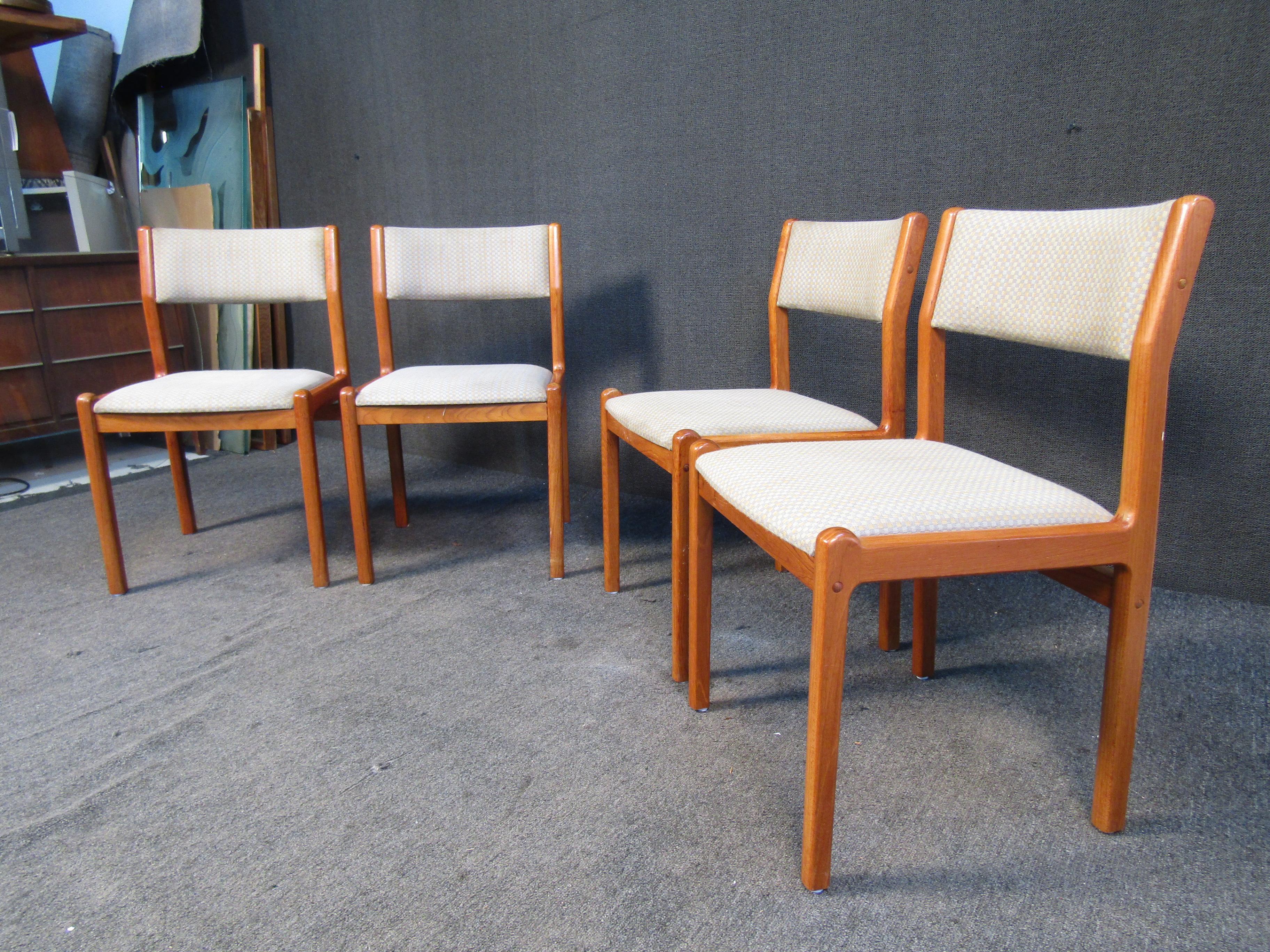 This set of four Mid-Century Modern dining chairs features a minimal design by J.L. Møller Højbjerg that emphasizes a rich teak woodgrain and warm beige upholstery. Please confirm item location with seller (NY/NJ).