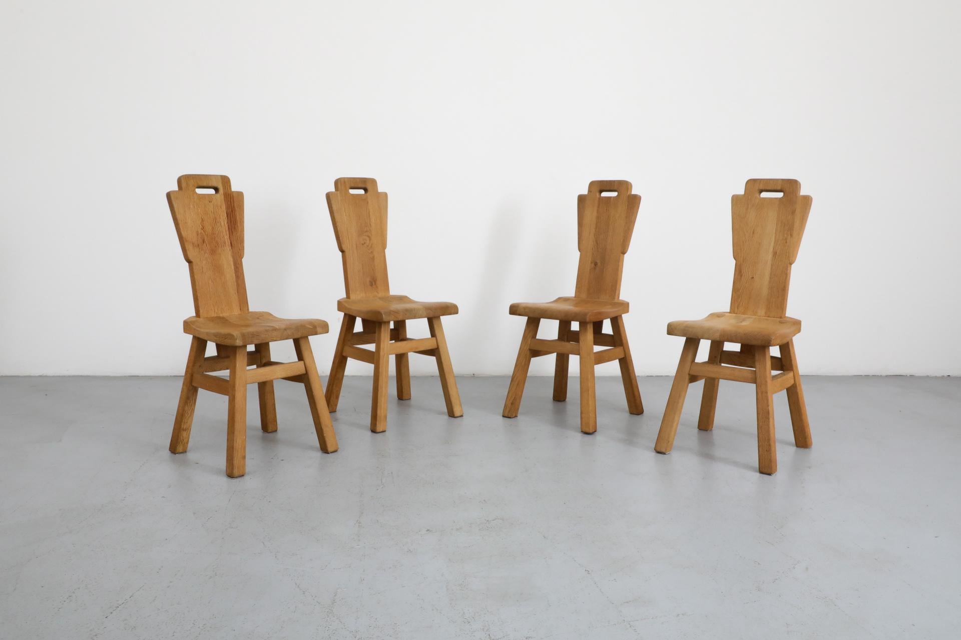 Set di 4 sedie da pranzo in stile Brutalista De Puydt con schienale alto in rovere naturale, gambe squadrate e robuste, fissaggio con tensione a pioli, intagli per le maniglie, lavorazione artigianale e falegnameria di qualità. Queste sedie non