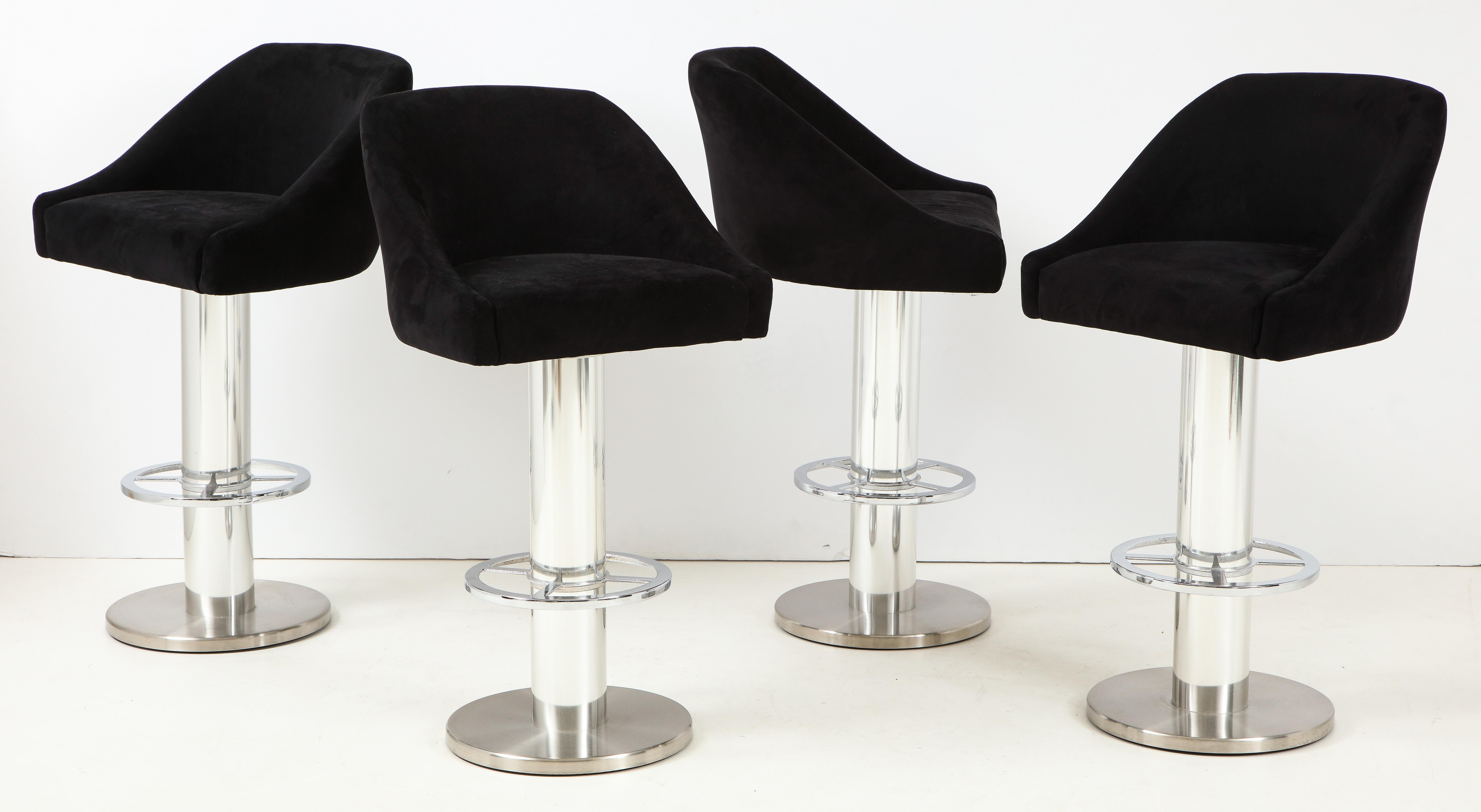 Set of four Design For Leisure barstools in chrome with original black Ultrasuede fabric. Well-made with heavy columnar chrome bases with footrests. Original label dated to 1997. In standout original condition with only minor wear consistent with