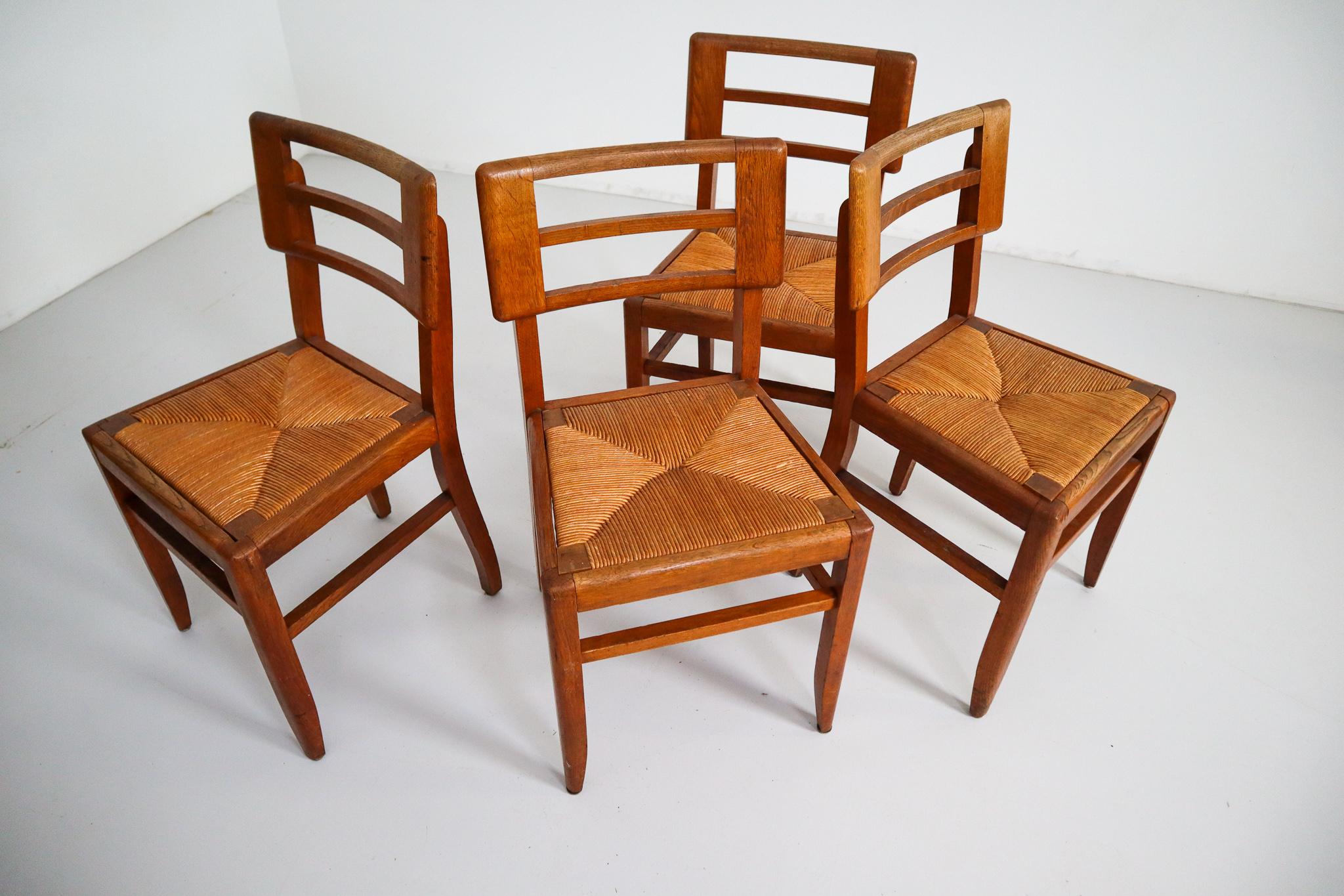 Modernist set of four chairs by designer Pierre Cruege made in France, 1940s. These models feature a sturdy backrest, consisting of wooden elements connected to each other by four slats. The seat is executed in woven cane. Works by French designer