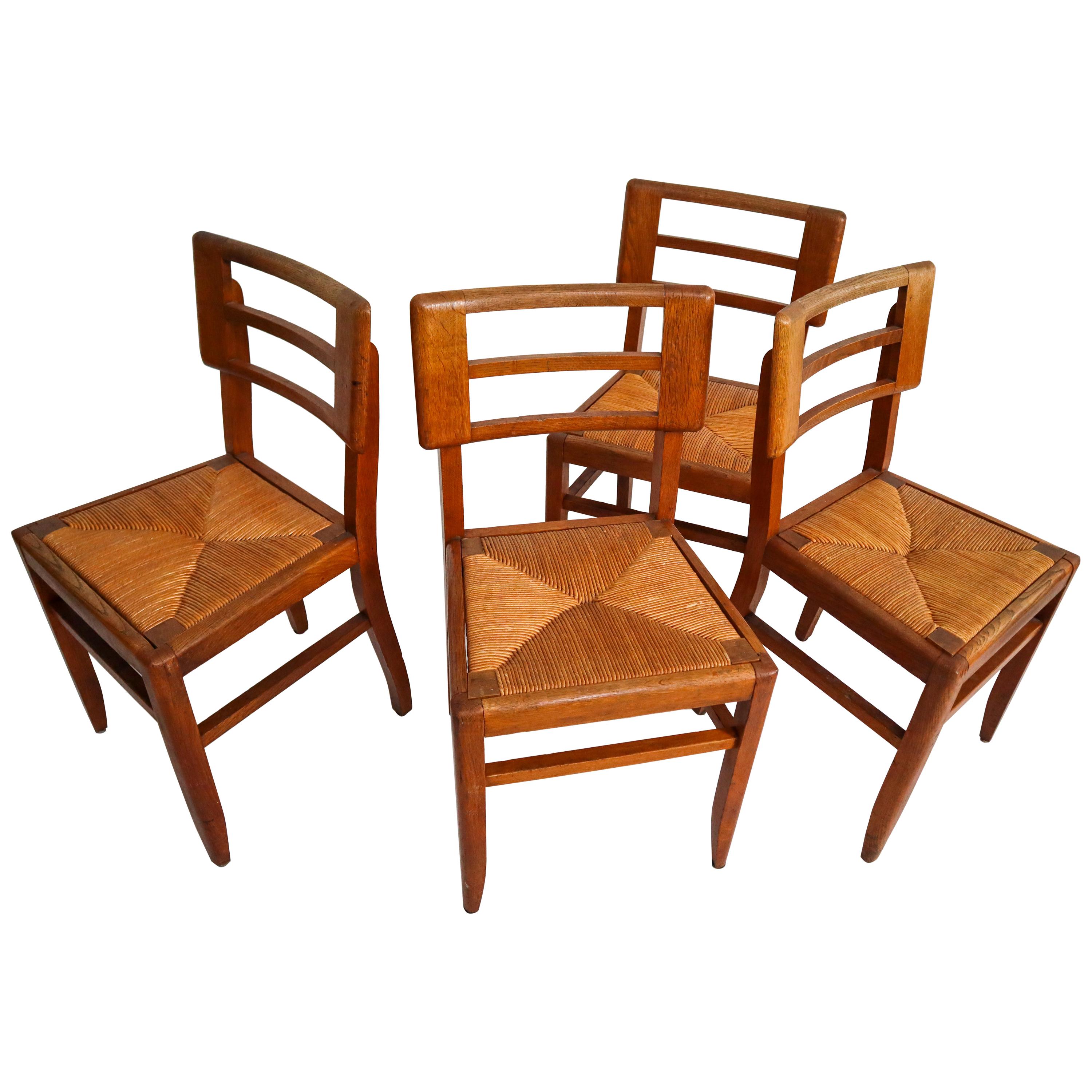 Set of Four Dining Chairs by Pierre Cruege in Oak and Cane, France, 1940s