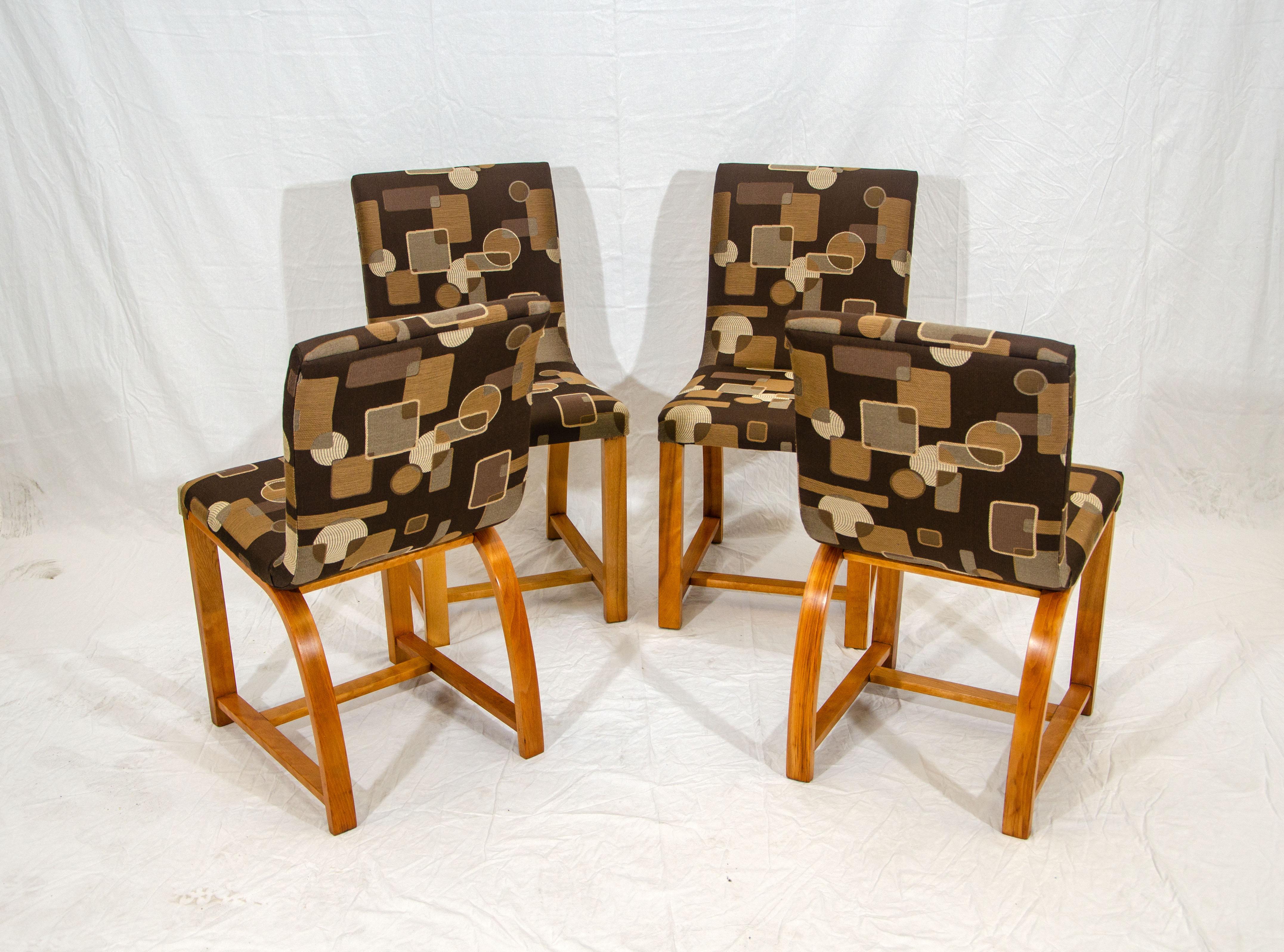 Set of four dining chairs designed by Gilbert Rohde for Heywood Wakefield and manufactured from 1936 through 1941. The new upholstery is pattern matched on all four chairs.