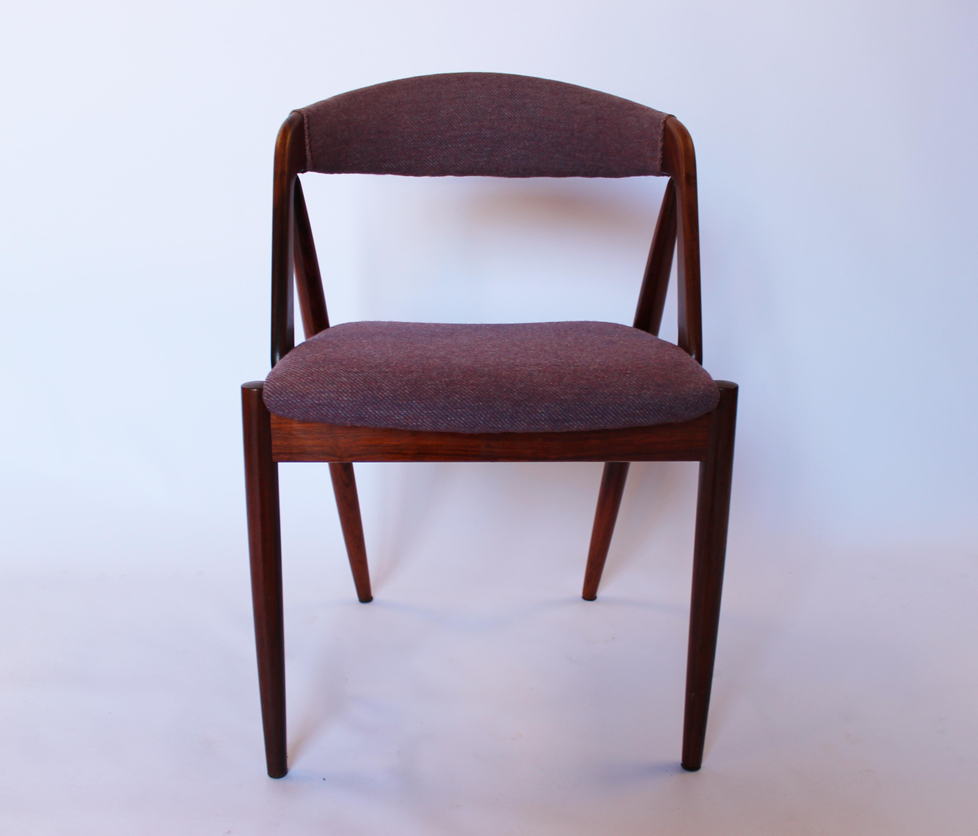 A set of four dining room chairs, model 31, designed by Kai Kristiansen in 1956 and manufactured by Schou Andersen in the 1960s. The chairs are of rosewood and upholstered in purple fabric.