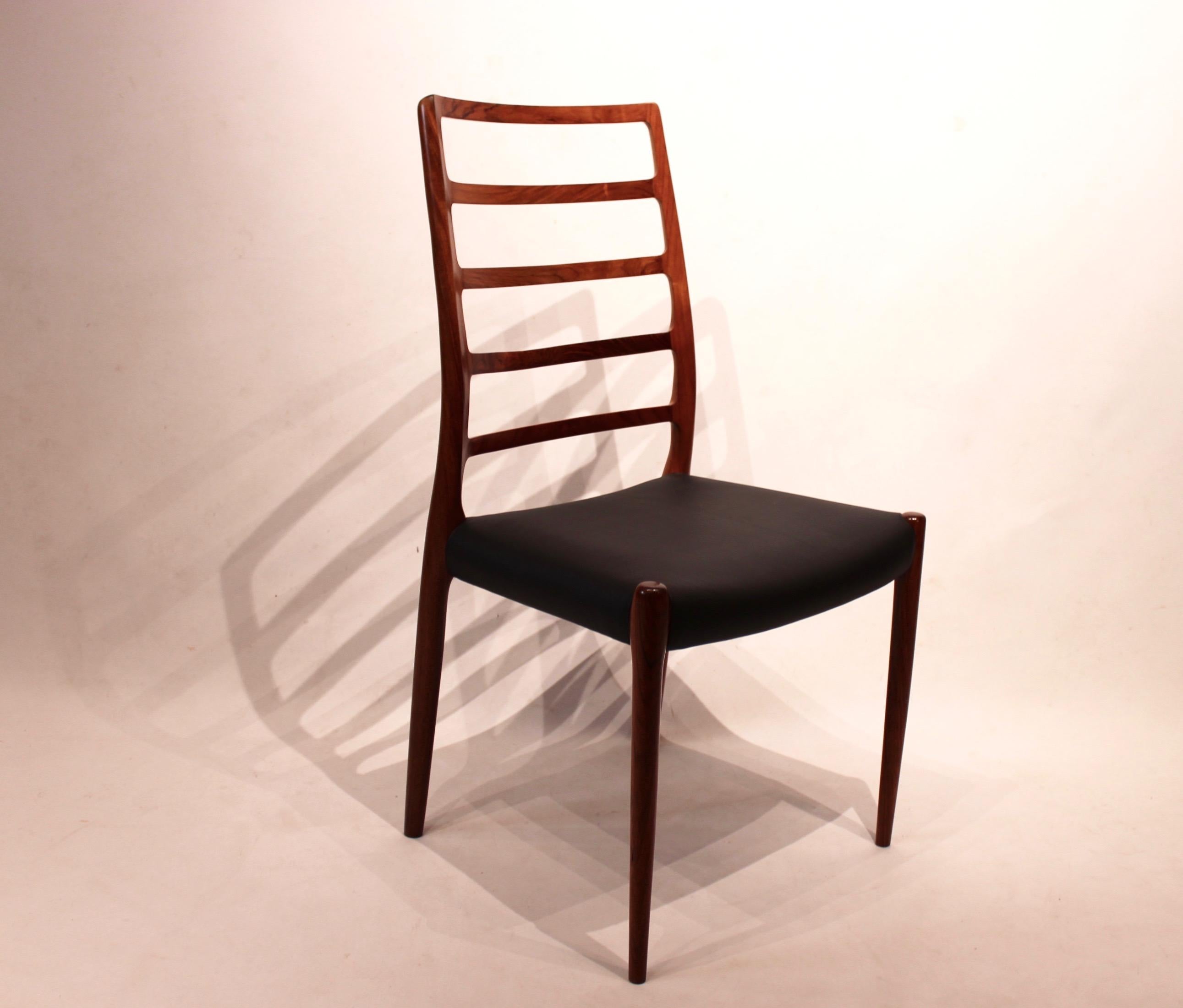 Set of four dining chairs, model 82, designed by N.O. Møller from the 1960s. The chairs are of rosewood and upholstered with black leather.