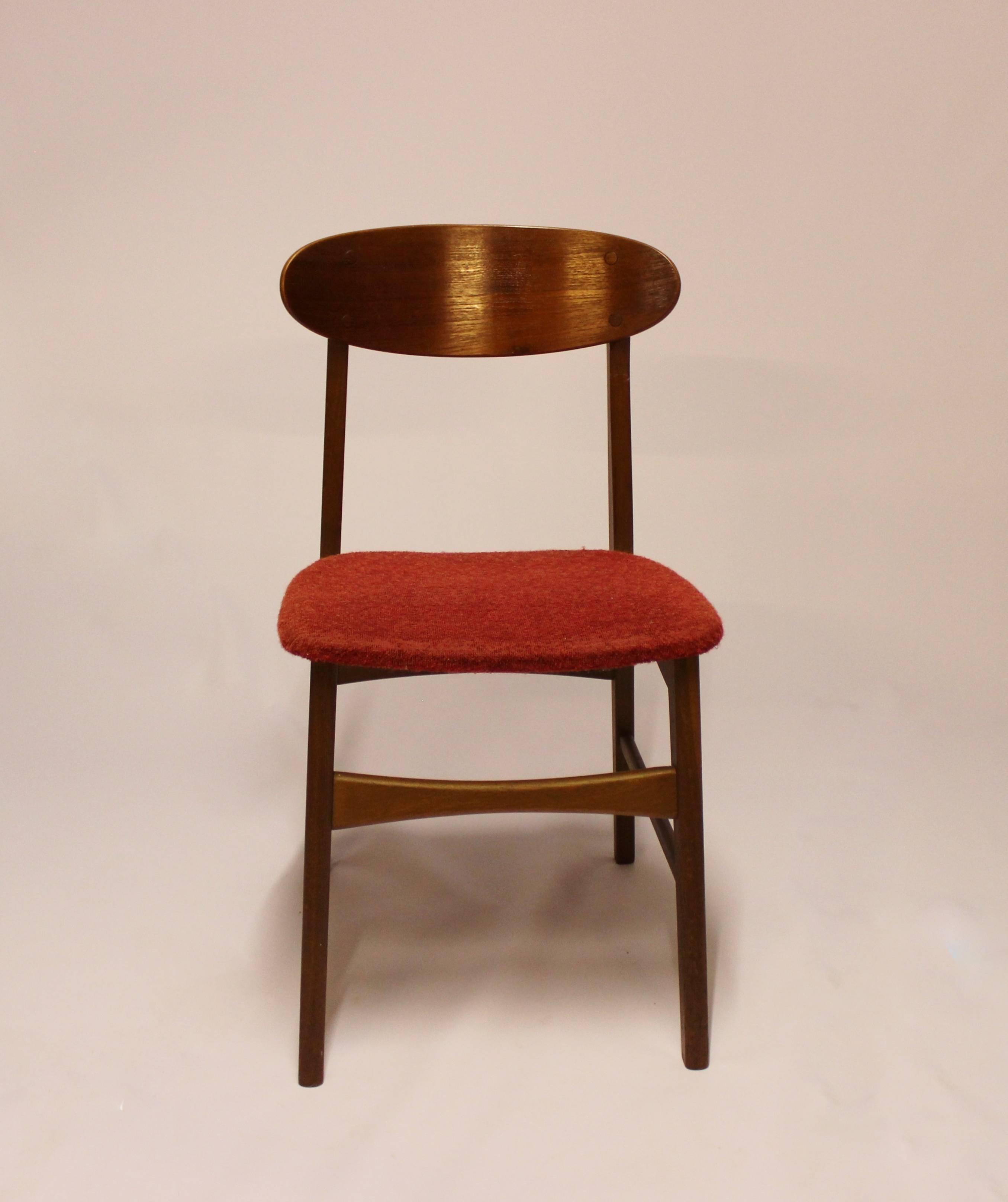 A set of four dining room chairs in teak and upholstered with red fabric, of Danish design from the 1960s. The chairs are in great vintage condition.