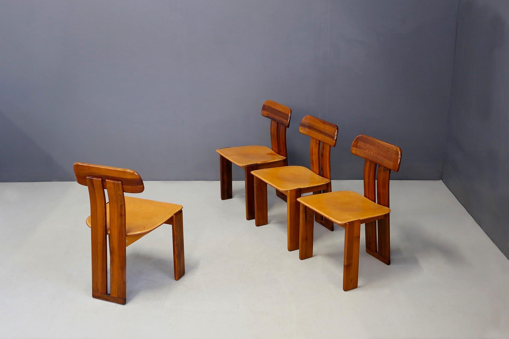 Sapporo for Mobil Girgi, four dining chairs in walnut and beige leather, 1970s.
Set of four sculptural chairs with semi-curved wooden backrests, composed of two vertical slats spaced one from the other. The front legs are straight and consist of two