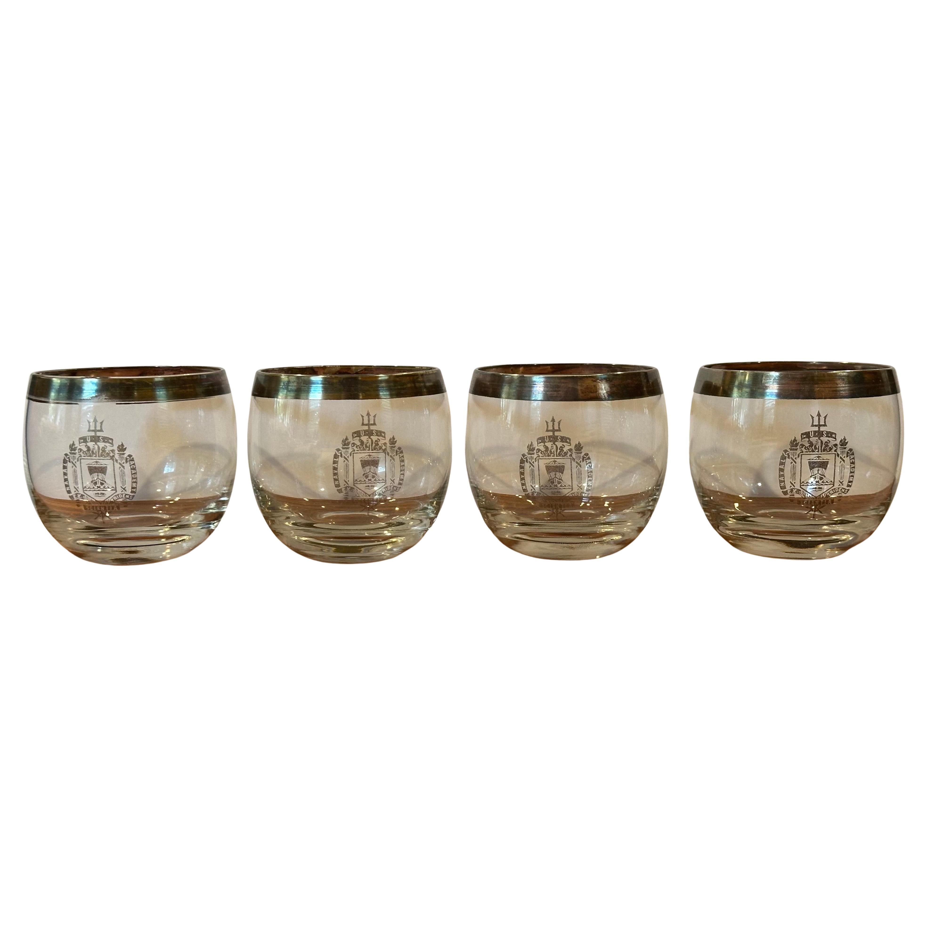 Set of four Dorothy Thorpe silver band roly poly cocktail glasses with Naval Academy seal, circa 1960s.  The set are in good vintage condition with some fading to the graphics and measures 3.25