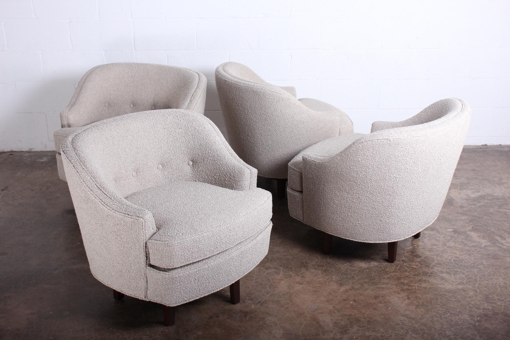 A set of four swivel chairs on walnut bases. Designed by Edward Wormley for Dunbar. Fully restored and upholstered in Rubelli boucle fabric.