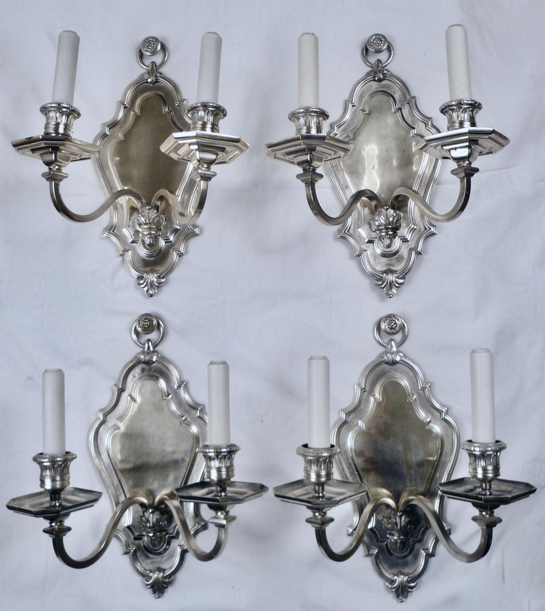 This set of four silver sconces by Caldwell feature classic early Georgian style details, including acanthus leaves and floral rosettes.