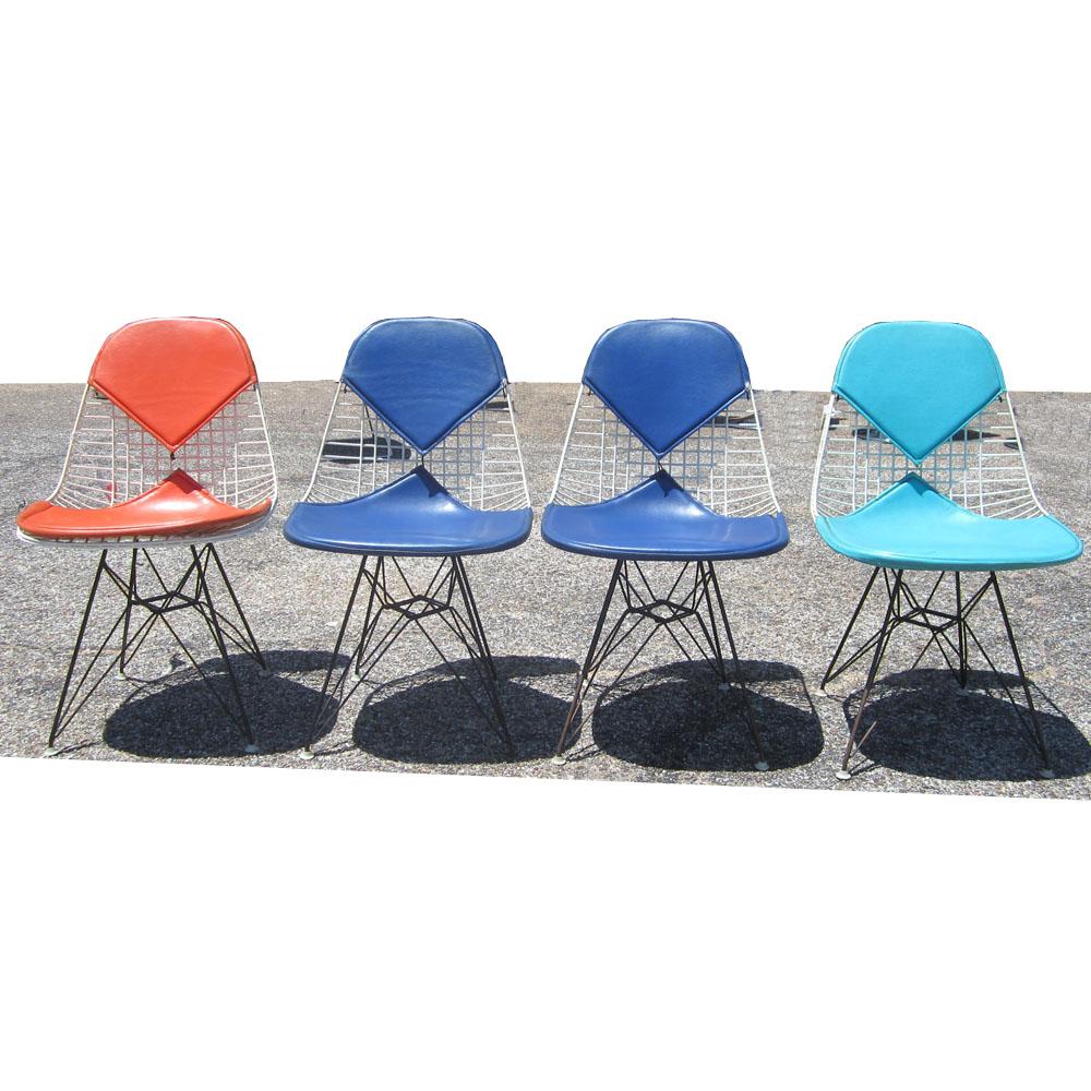 A set of four Eames DKR chairs for Herman Miller. The frame for these chairs is made of a steel wires welded together, powder coated white on a black Eiffel base. The Bikini pad coverings are the original Herman Miller designed by Alexander Girard