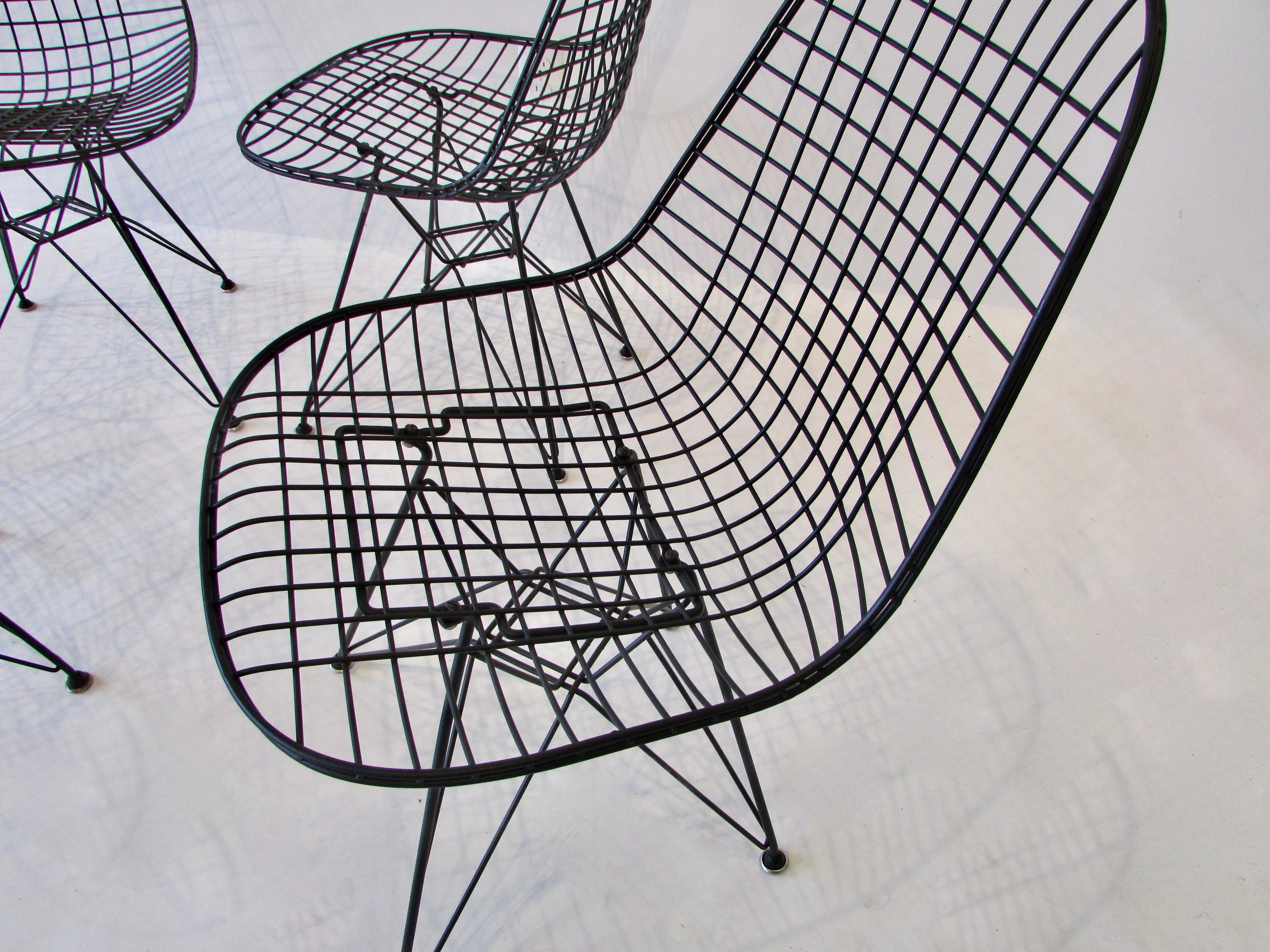 Chaises en fil de fer Charles et Ray Eames pour Herman Miller DKR sur des bases en forme de tour Eiffel. Les quatre chaises ont été remises à neuf avec un revêtement en poudre noir mat de ton correct. Trois chaises ont des patins de remplacement de