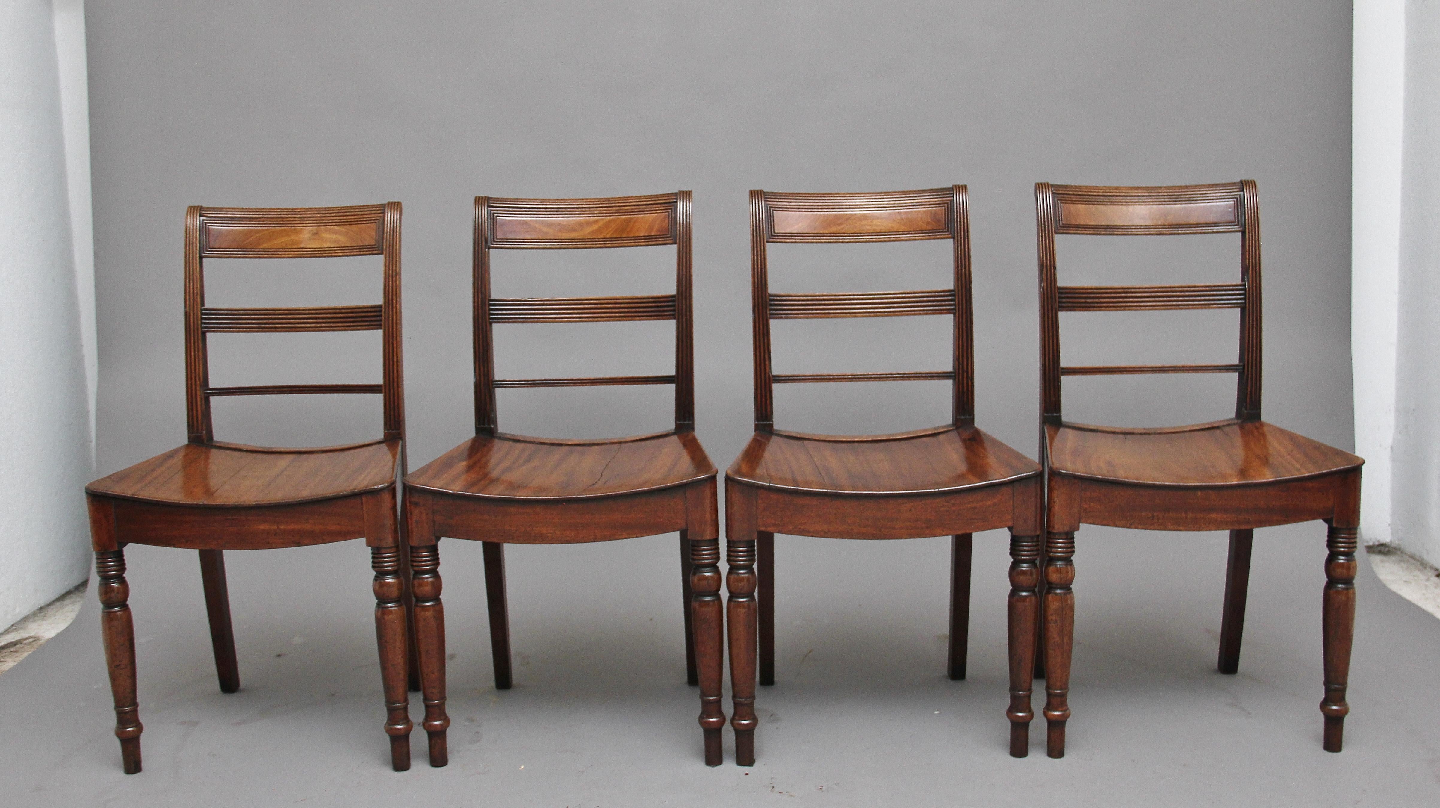 A set of four early 19th century mahogany side chairs with a slightly arched hardwood seat, having reeded back rails, supported on outswept back square legs and elegant turned front legs, circa 1830.