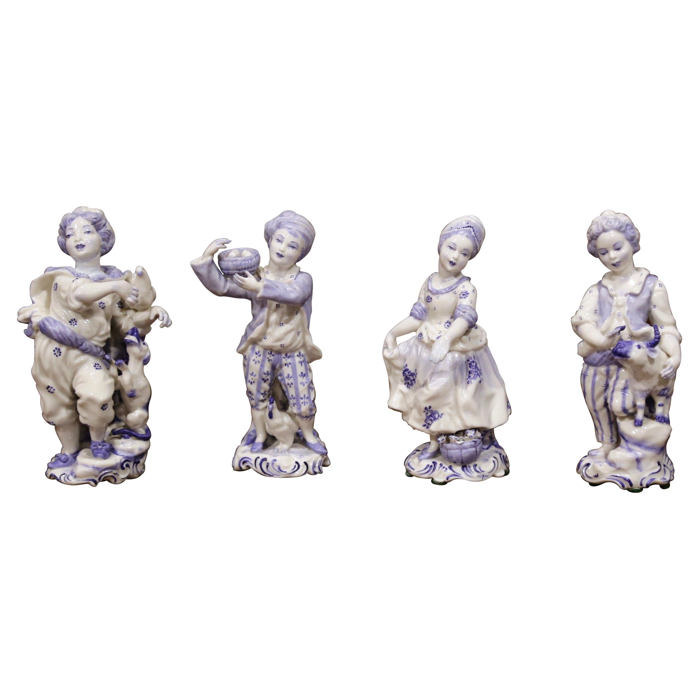 Ensemble de quatre figurines hollandaises en porcelaine de Delft peintes à la main du début du 20e siècle en vente