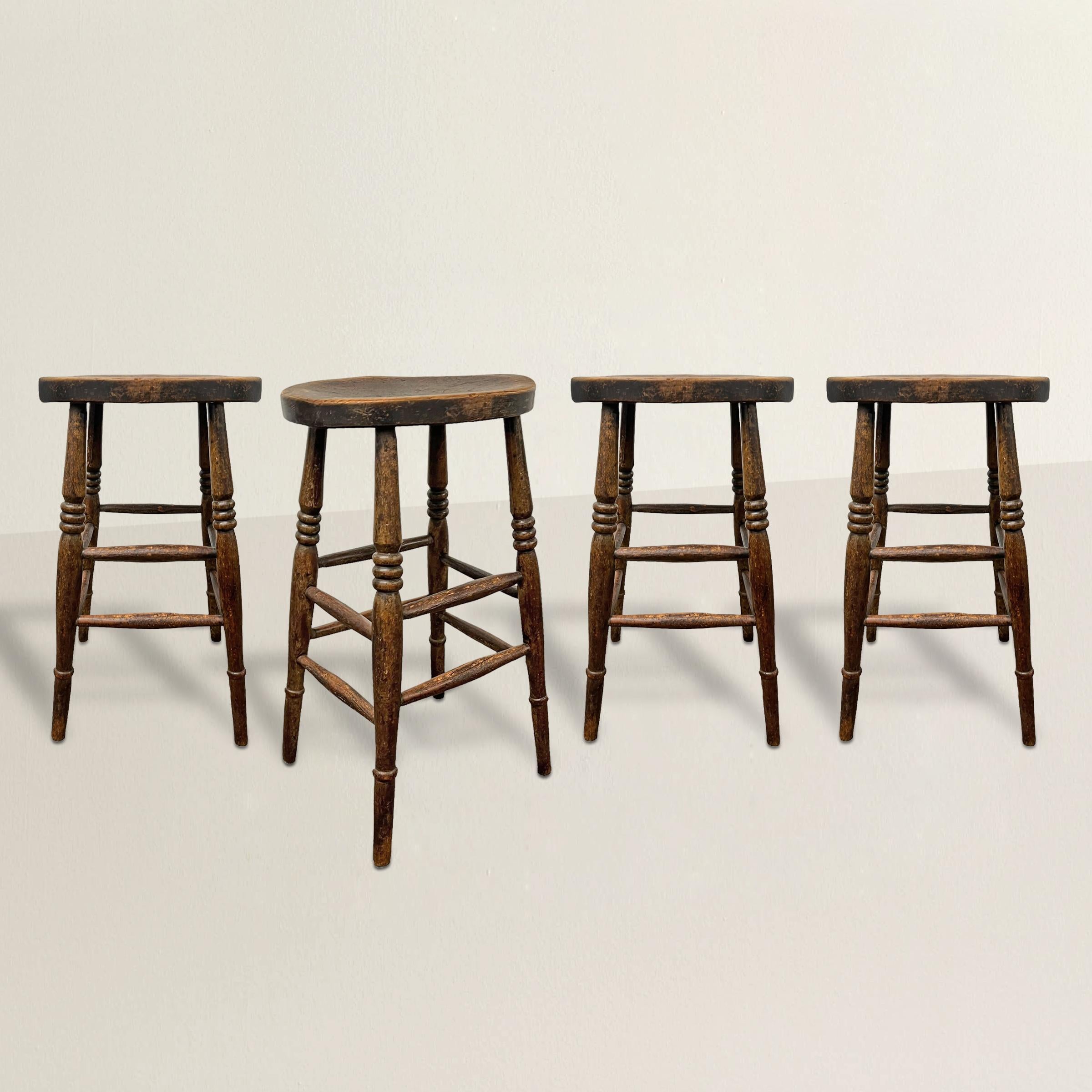 These early 20th century English oak counter height bar stools epitomize the timeless charm of pub culture in England. Crafted with meticulous attention to detail, each stool features oval and indented seats atop four tall, slender turned legs
