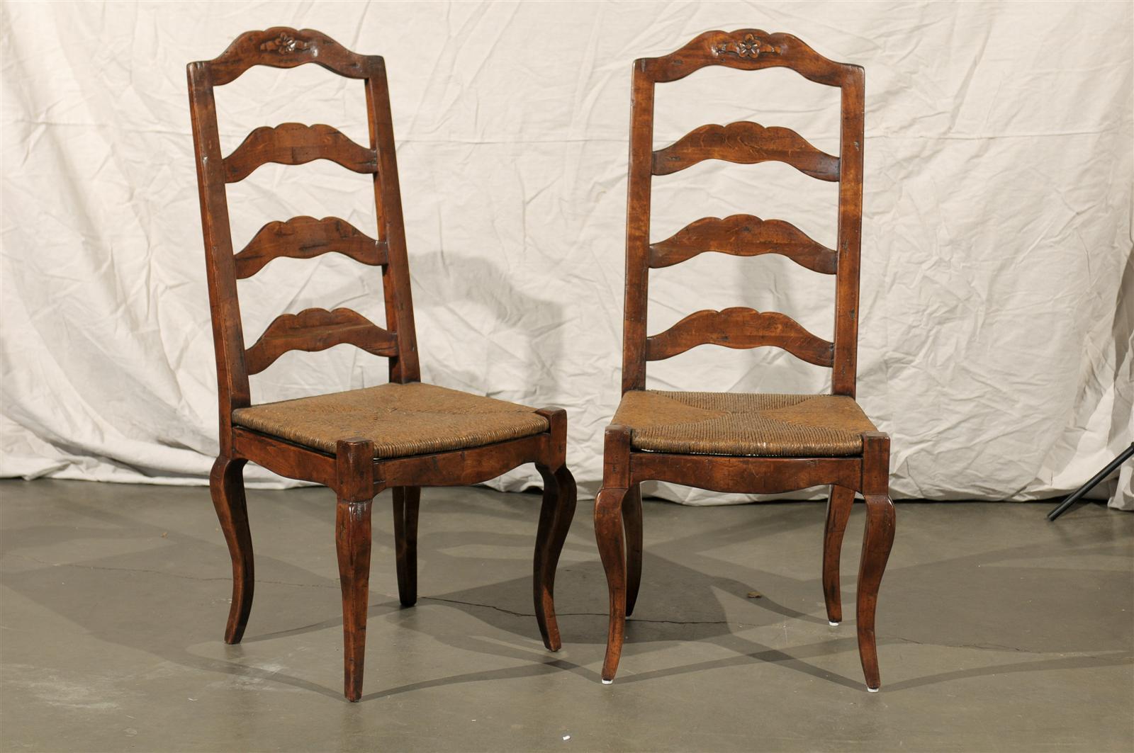 Set of four early 20th century French Provincial ladder back rush seat chairs.