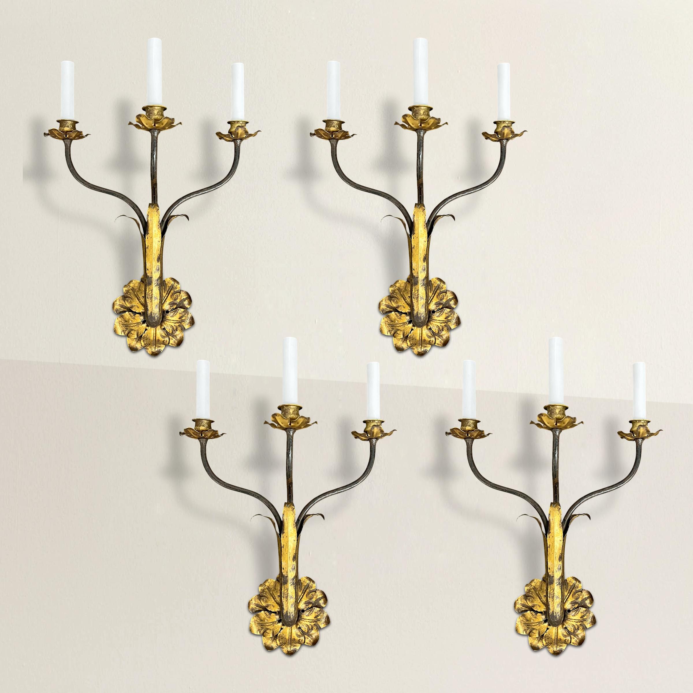 Elevate your interior with this exquisite set of four early 20th-century Italian three-arm sconces, newly electrified for modern convenience. Crafted from gilt tole and steel, these sconces embody timeless elegance and refined craftsmanship. Each