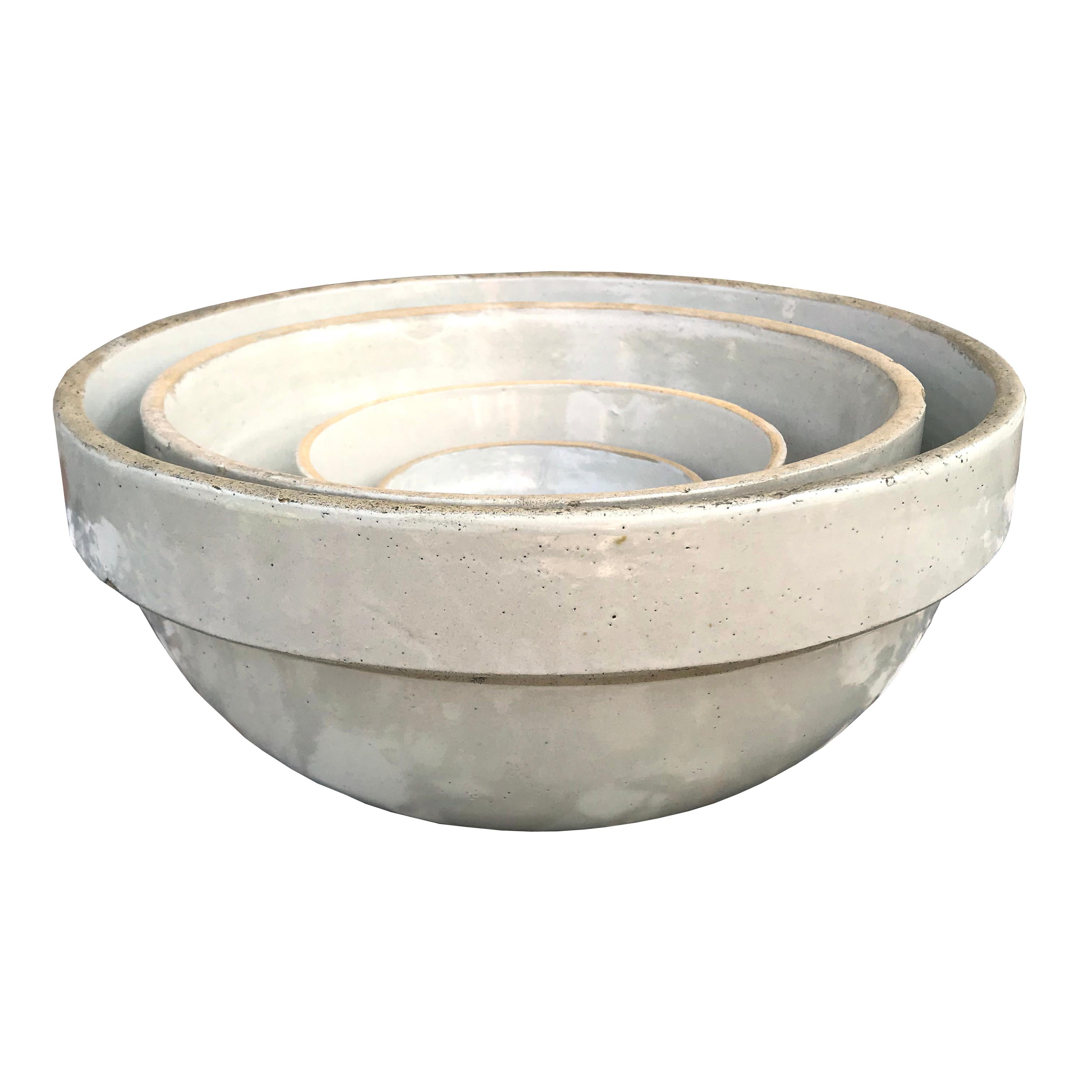 A lovely assembled set of four early 20th century American zinc-glazed stoneware mixing bowls of simple, but sophisticated, forms and similar cream colors. The extra large bowl is marked, 