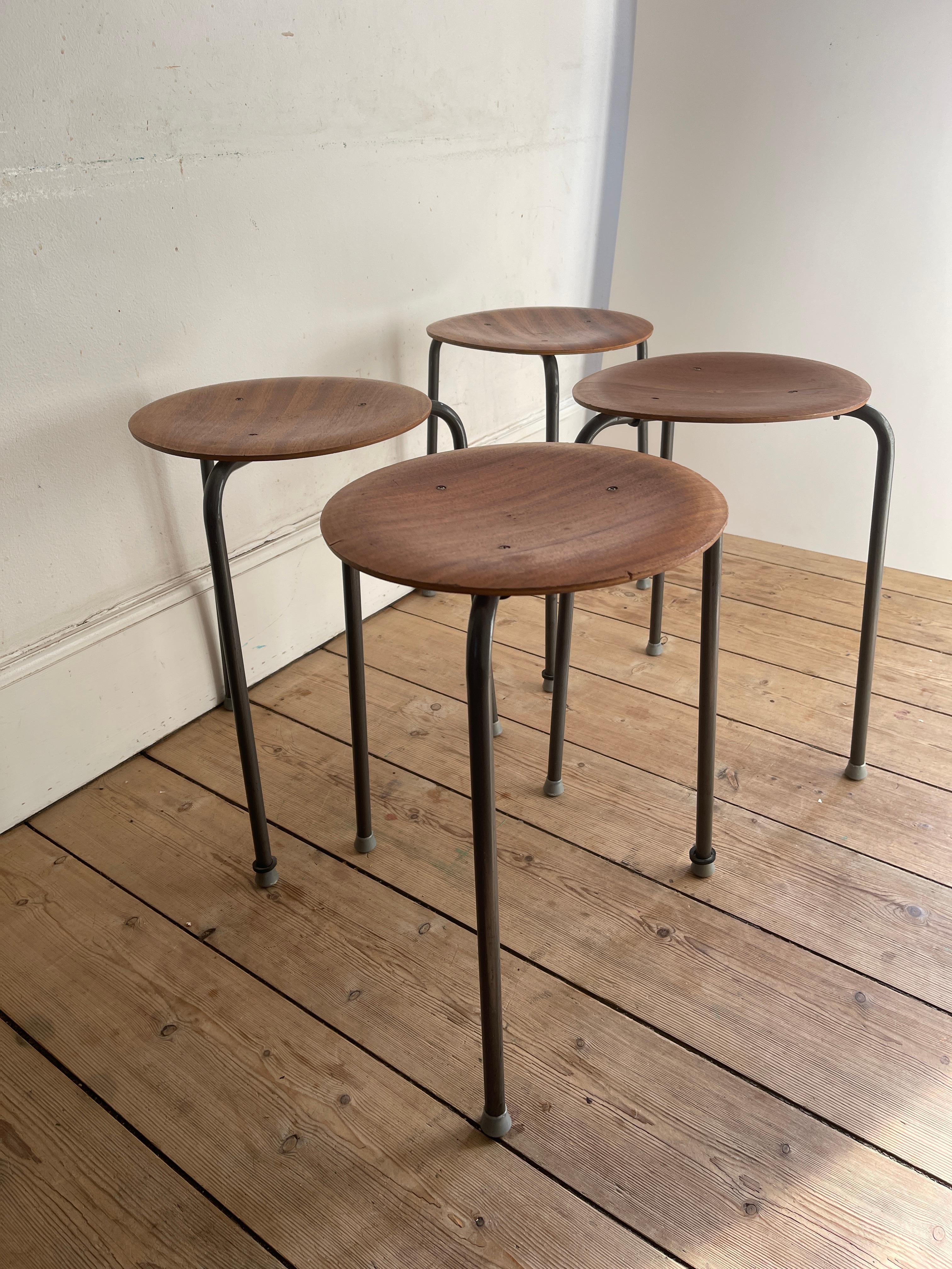Set of four original early production Arne Jacobsen teak dot stools. with enamelled metal tripod legs. 

Arne Jacobsen co-developed the Dot stool with the Danish furniture manufacturer Fritz Hansen in the early 1950s. Like the Ant chair from 1952,