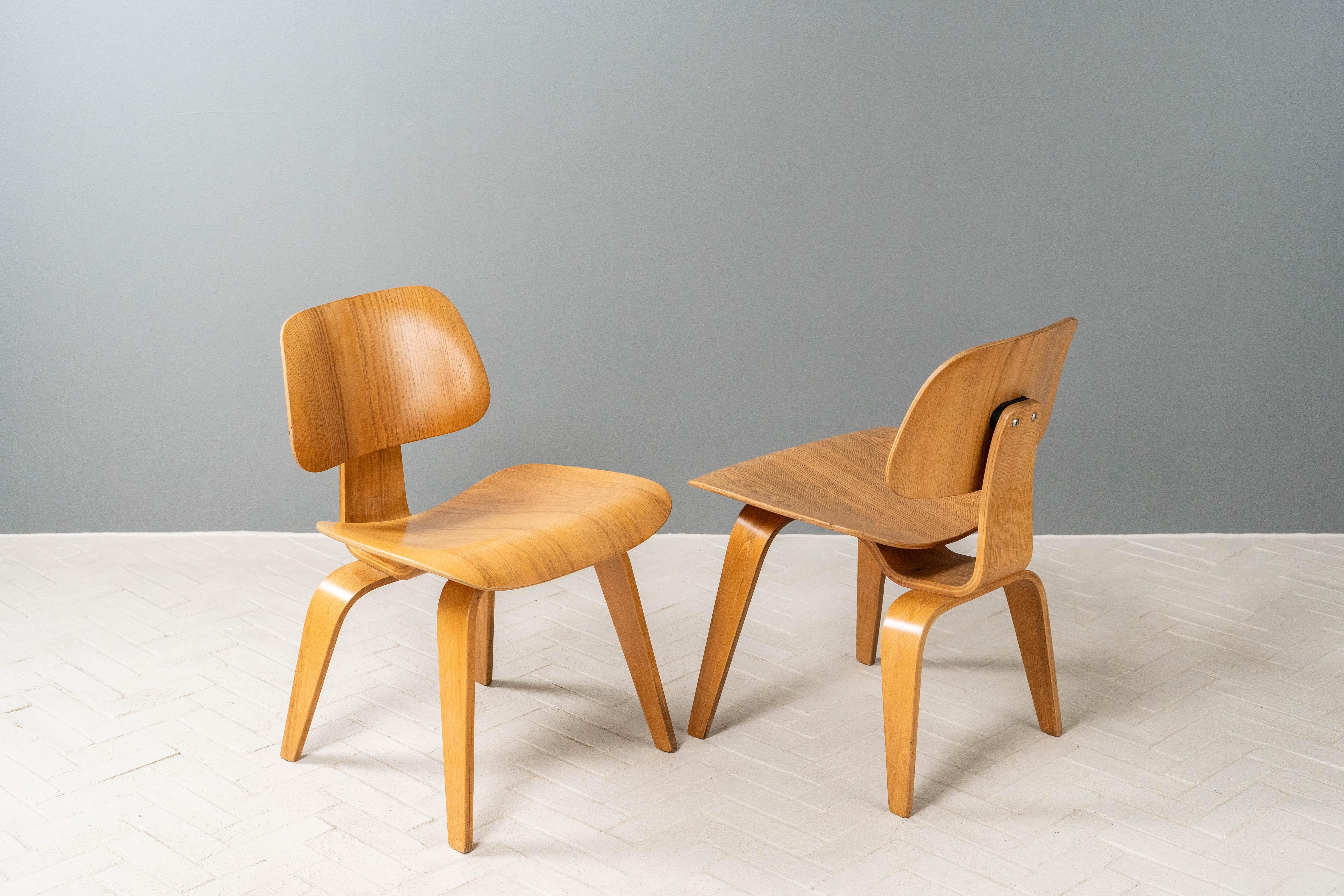 EE.UU., hacia la década de 1950. Raro y temprano grupo de cuatro DCW (altura de comedor / silla auxiliar / bases de madera) de Charles & Ray Eames. Cada uno de ellos está fabricado con el característico contrachapado moldeado y acabado con chapa de