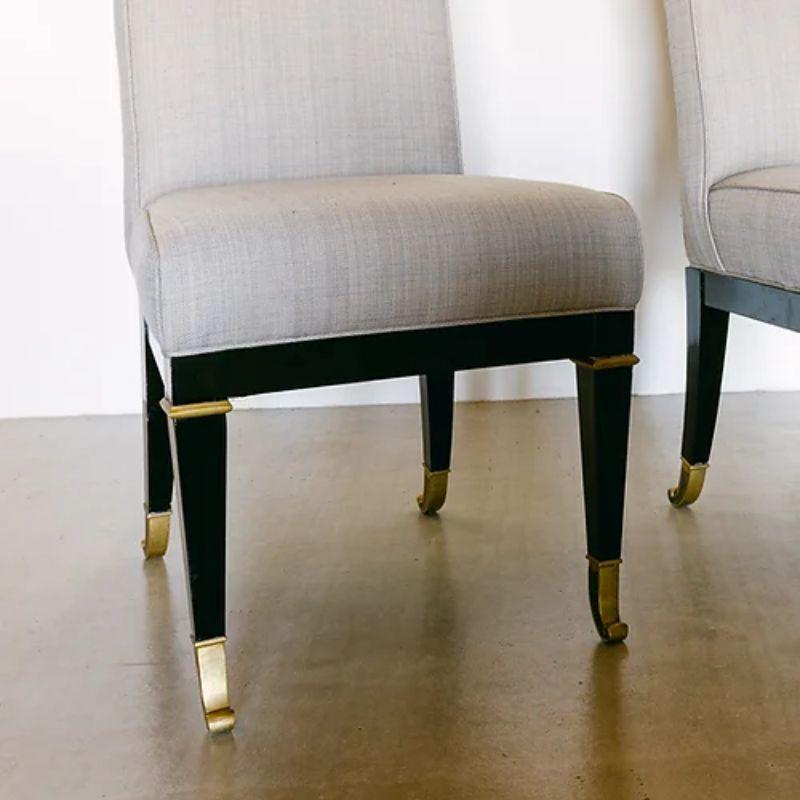 A set of four ebonised and brass framed dining chairs designed by Mastercraft, upholstered in a grey linen 1970s.

Mastercraft is synonymous with high style and high society living from mid to late 20th century. The American based company created