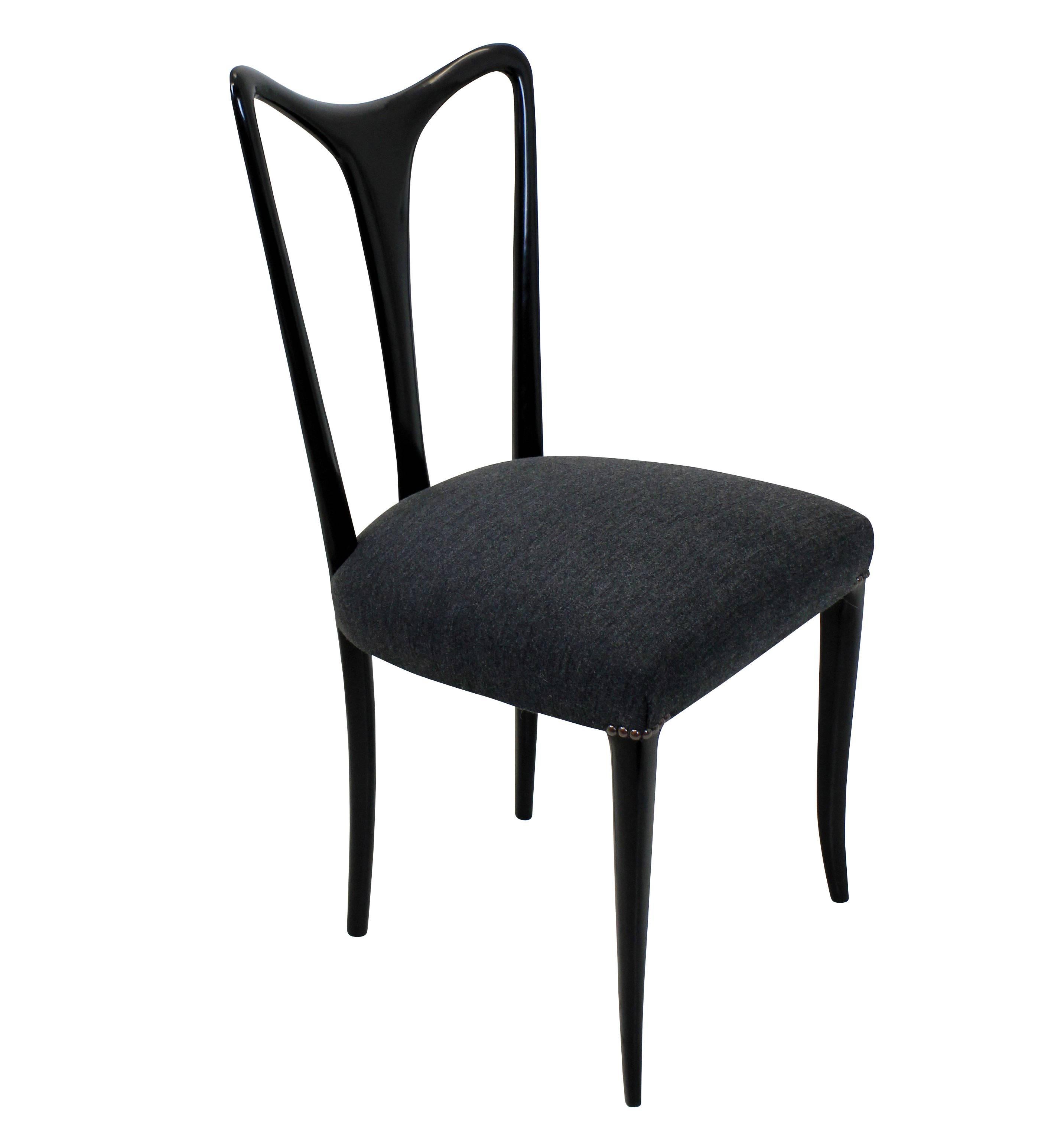 A set of four elegant dining chairs by Ulrich. Of finely tapering design in ebonized wood with newly upholstered grey seats.