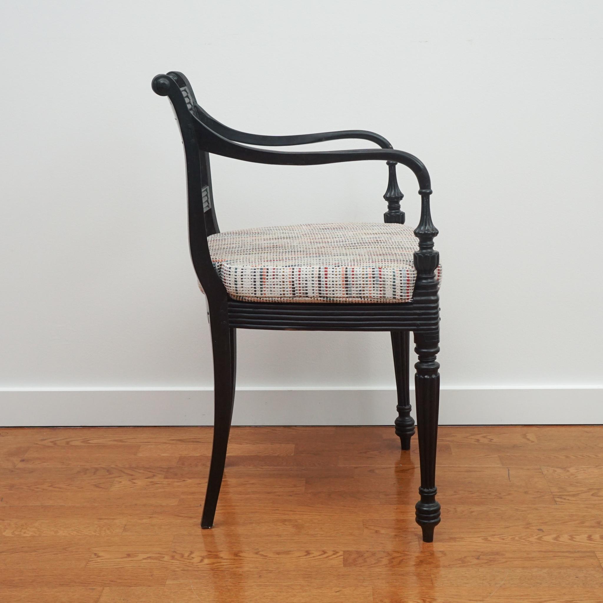The set of four ebony carved arm chairs, shown here, are from India, circa 19th century. Featuring hand-caned seats, each chair is intricately carved of ebony wood and as stylish today as they were when they were first made. Each chair comes with