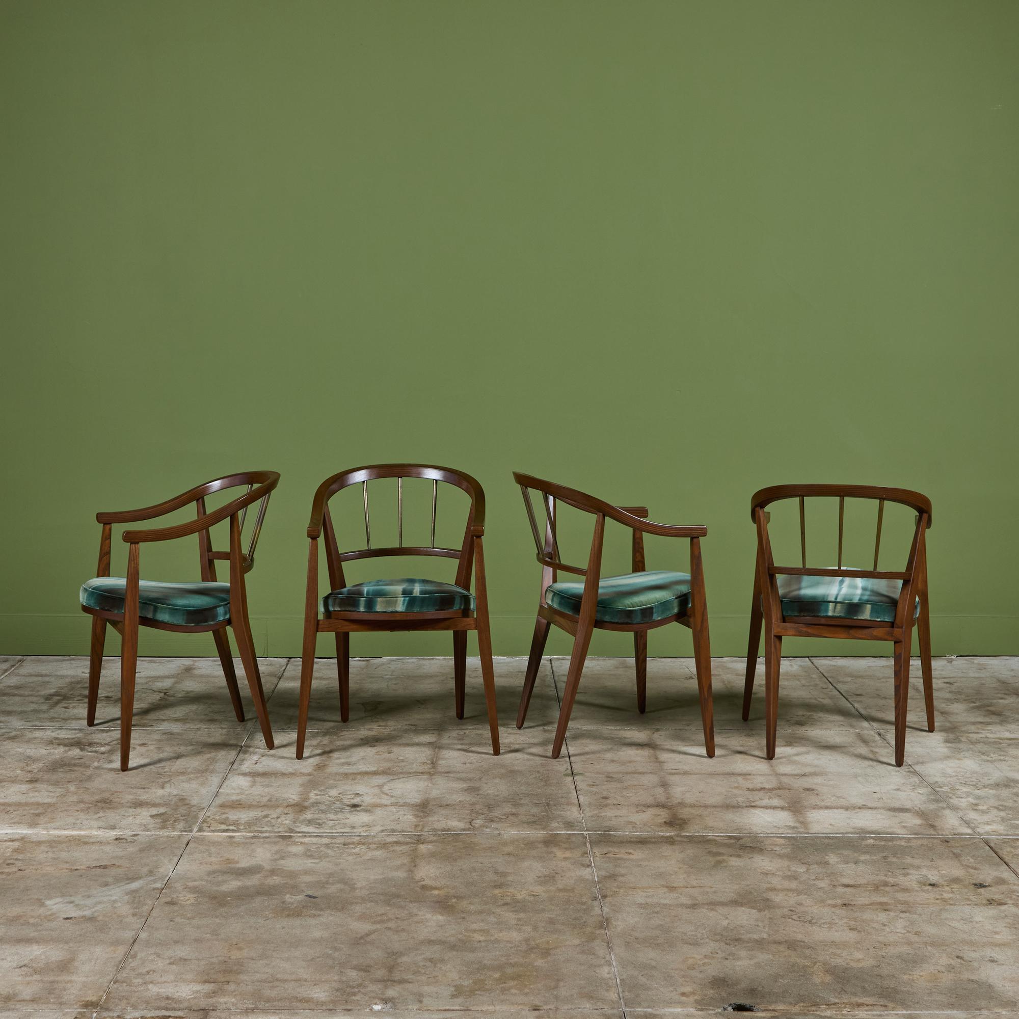 Ensemble de quatre fauteuils de salle à manger en noyer foncé avec pieds effilés par Edward Wormley pour Dunbar, A.I.C., vers les années 1960. Les coussins d'assise ont été retapissés avec du velours bleu et vert à l'imprimé linéaire et présentent
