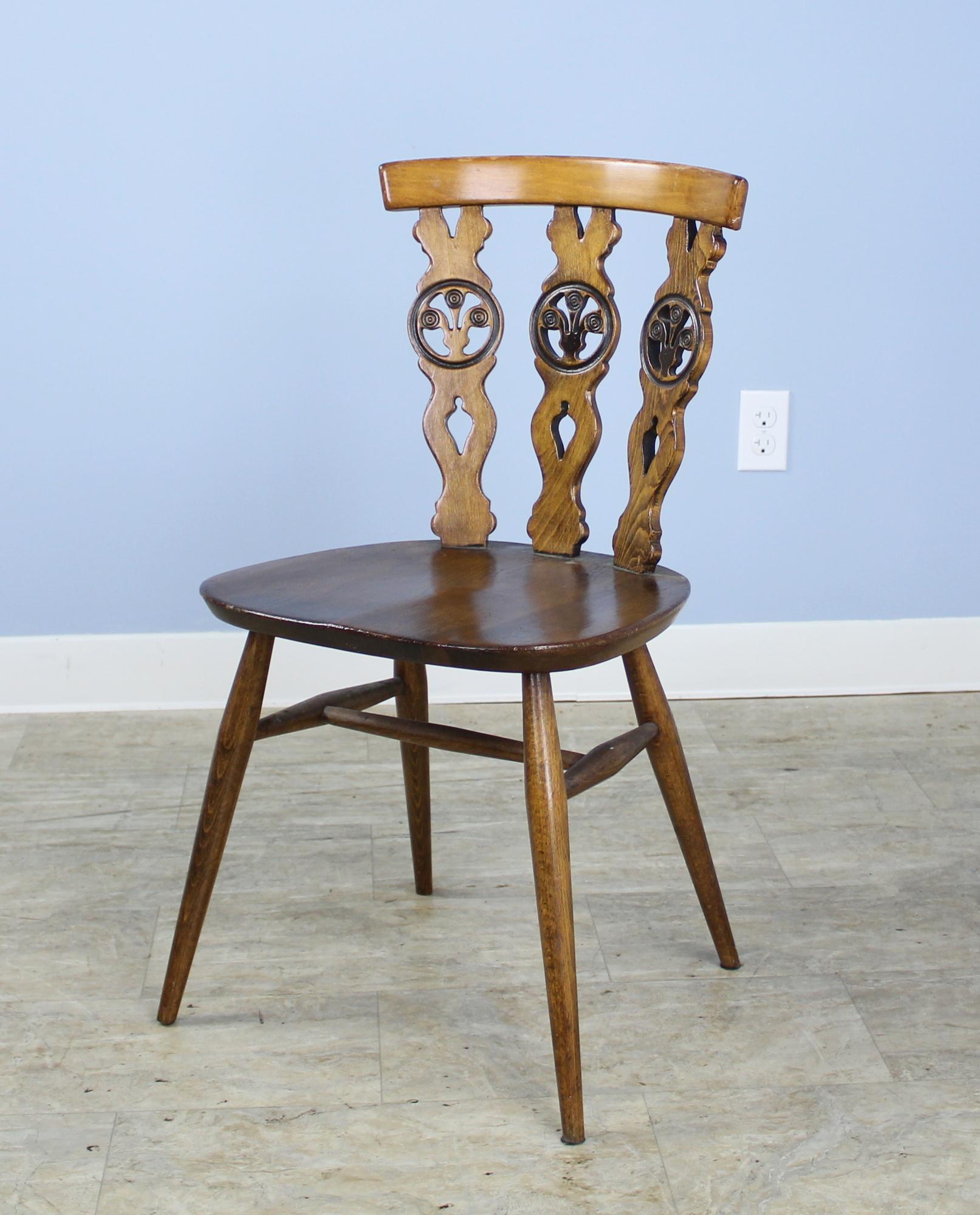 A charming 1920s set of four small kitchen chairs, each with the Prince of Wales feather motif carved into the back. The combination of dark elm and light fruit woods creates a nice color contrast in the design.