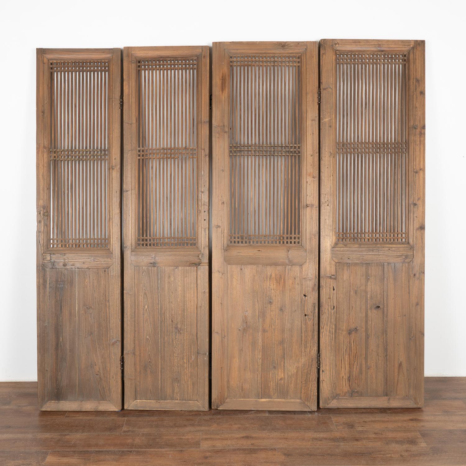 A set of four large natural elm wood interior folding screen panels with vertical fretwork that allows light to pass through the upper section.
Solid, stable and all hinges in place. Any scratches, cracks, dings, or age related separation are