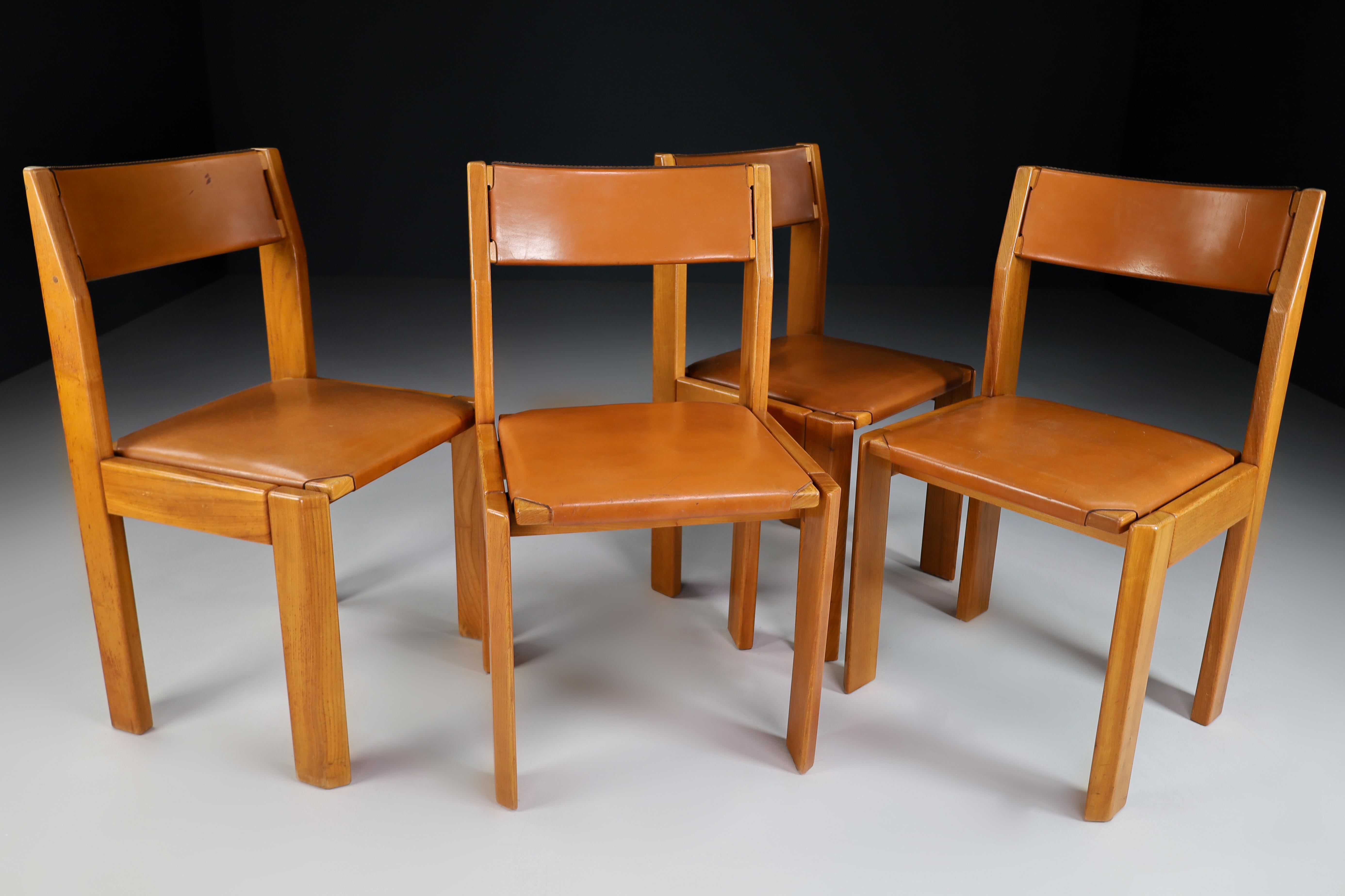 Maison Regain designed a gorgeous set of 4 dining chairs in France in the 1960s. A quality design in the manner of Pierre Chapo. The structure is in solid elm, and the seat and backrest are thick cognac leather with an attractive patina of age. In