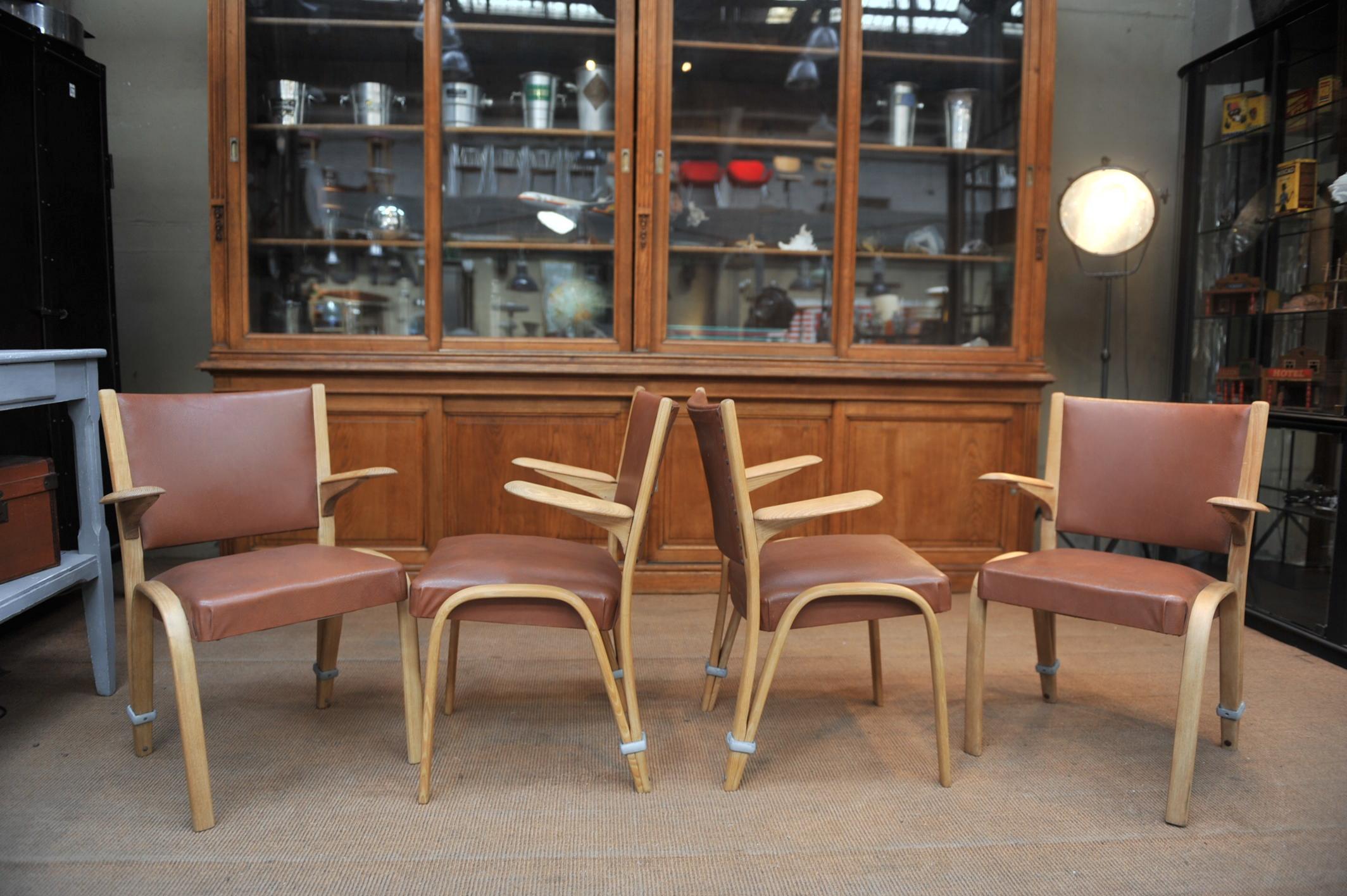 Set of four armchairs by Bow-Wood Villeneuve St George (FRANCE) . Elm wood structure and faux leather seat an back . very comfortable . circa 1950 send and waxed finish. one armchair has 2 front feet used .