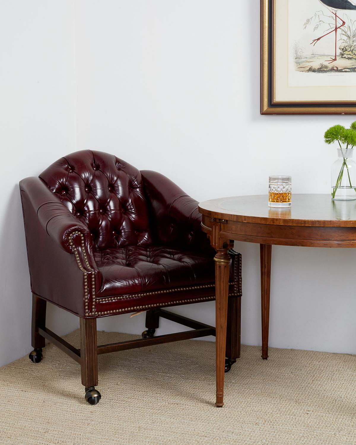 Stately set of four English Chesterfield style tufted leather executive desk or office chairs. Constructed from hardwood frames covered with soft, supple cordovan leather. Accented by brass nailhead trim with reeded front legs. Lovely style with a