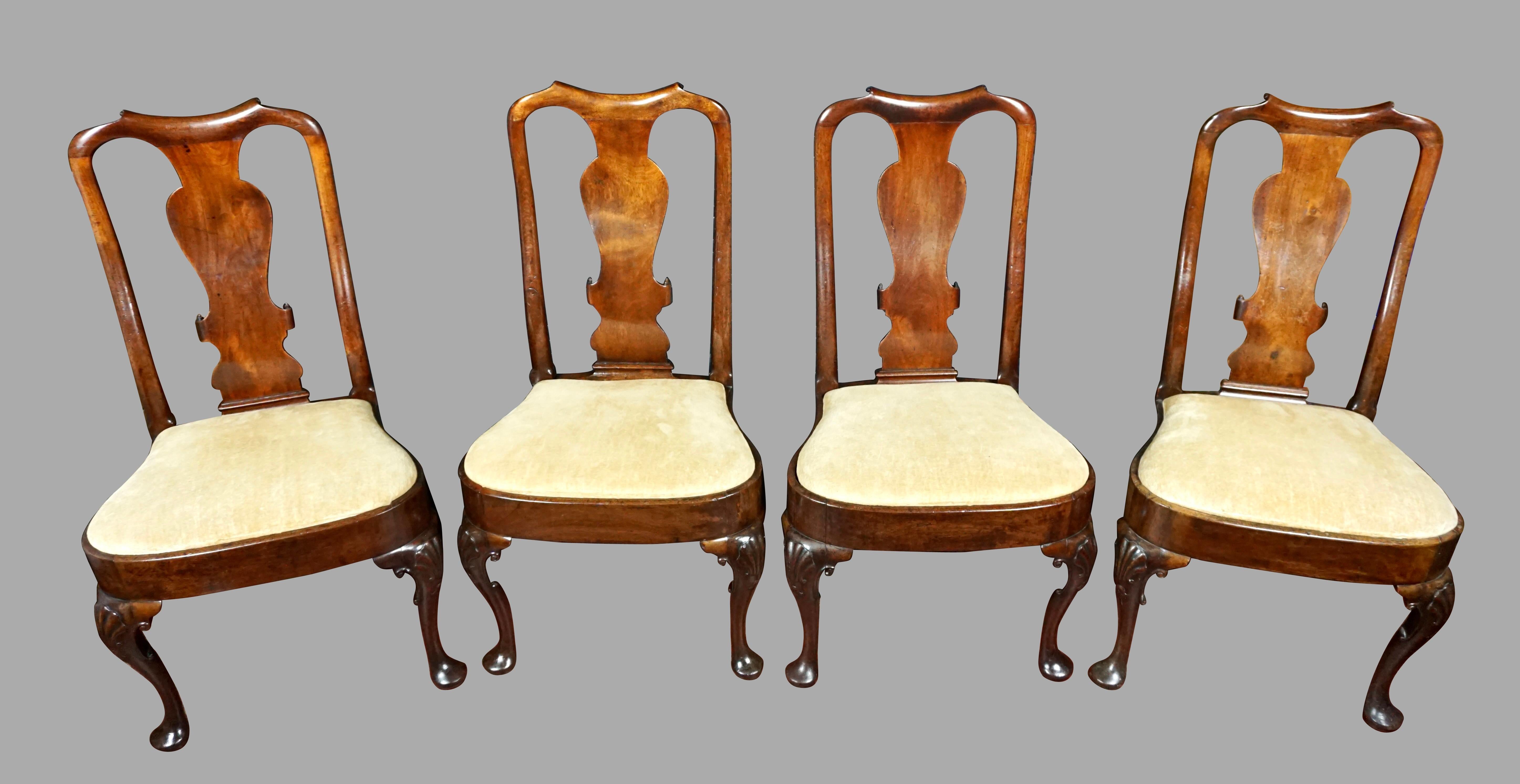 A set of 4 English George II period walnut side chairs of good scale, the undulating crestrail above a vasiform splat with carved volutes, terminating in a balloon seat with drop-in cushions. The cabriole legs are accented by well-carved shells at