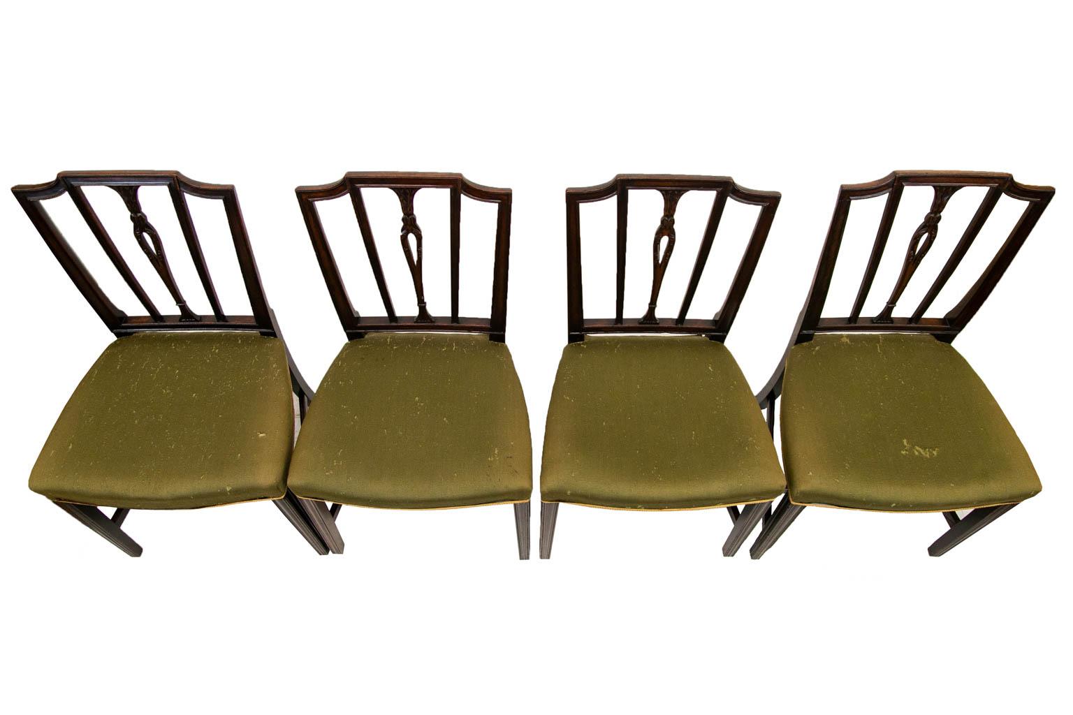 The back splat of this set of mahogany chairs has a pierced center splat carved with leaves and framed by four molded upright stiles. The legs have carved moldings and are joined by an 