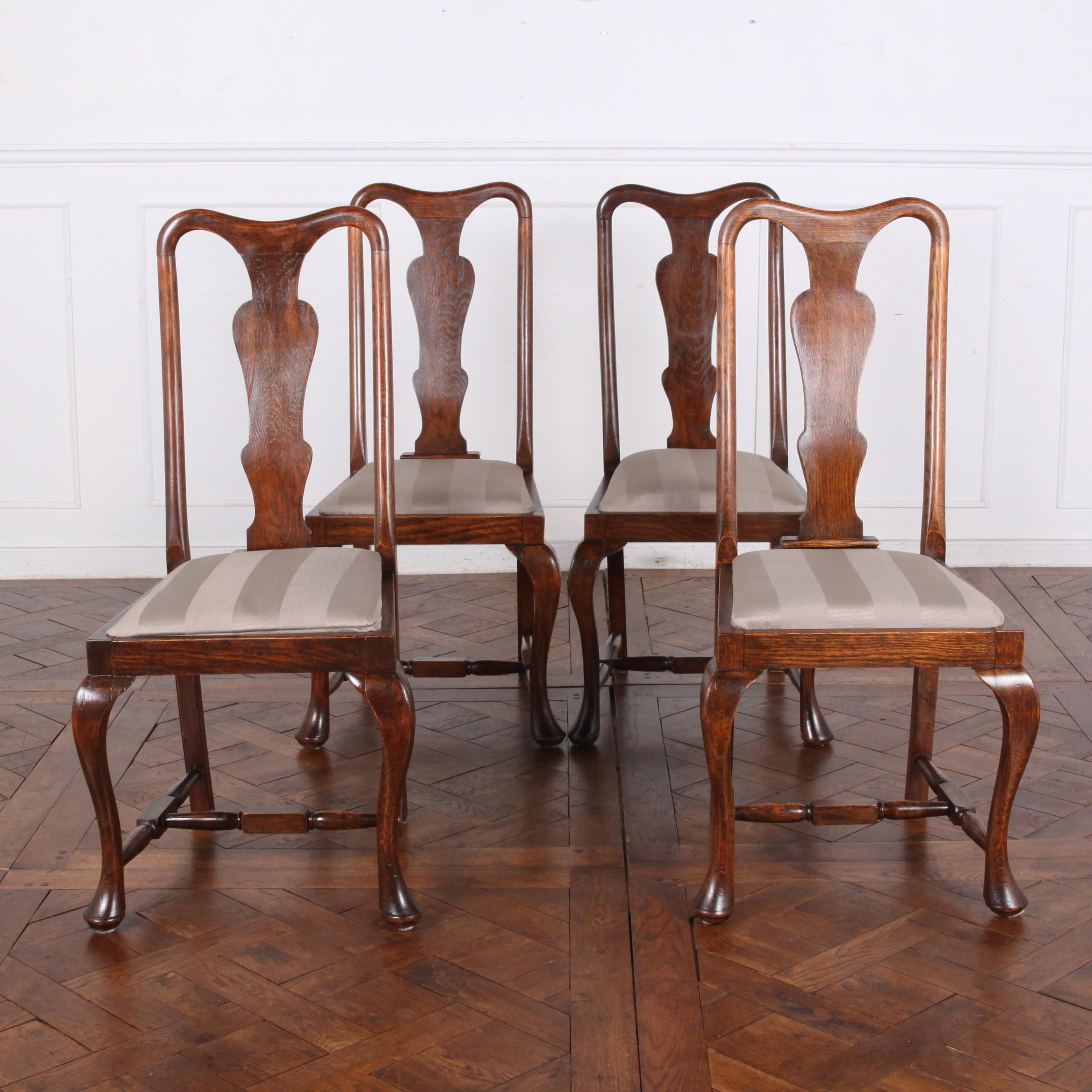 A set of four English Queen Anne style tall-backed dining chairs in oak with drop-in seats for simple re-upholstery. 


 